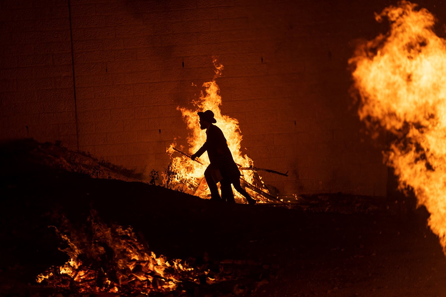  An ultra-Orthodox Jewish man walks through bonfires during the Lag BaOmer celebrations in Jerusalem Tuesday, May 9, 2023. (AP Photo/Ohad Zwigenberg) 