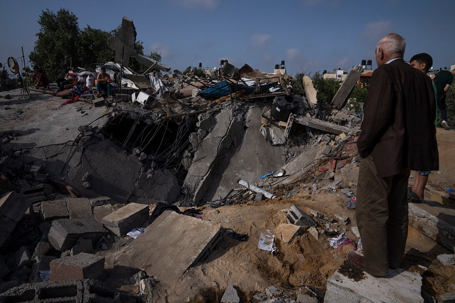  Palestinians inspect the rubble of a house after it was struck by an Israeli airstrike in Beit Lahia, northern Gaza Strip, Friday, May 12, 2023. (AP Photo/Fatima Shbair) 