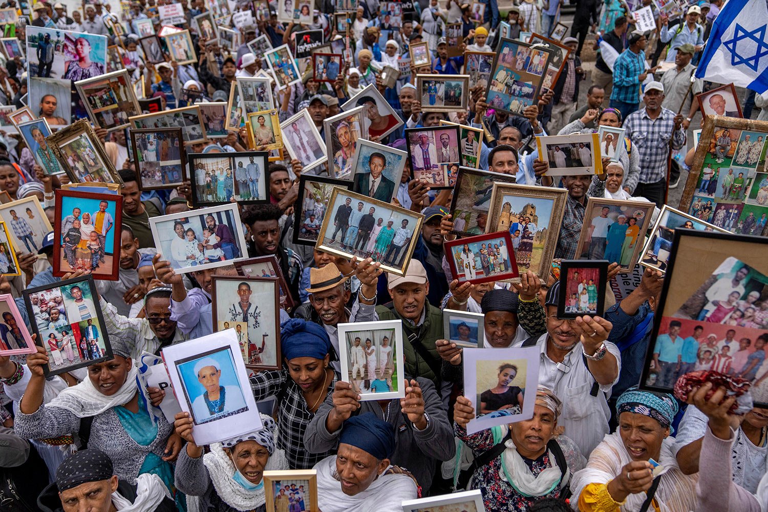  Ethiopian Israelis hold pictures of their relatives during a protest calling for the government to bring their remaining family members from Ethiopia to Israel in front of the Prime Minister's office in Jerusalem, Sunday, May 28, 2023. (AP Photo/Oha