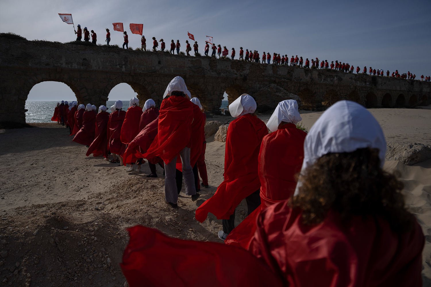  Protesters dressed as characters from The Handmaid's Tale TV series attend a protest against Prime Minister Benjamin Netanyahu's government at the beach in Cesarea, Israel, Tuesday, May 16, 2023. (AP Photo/Oded Balilty) 