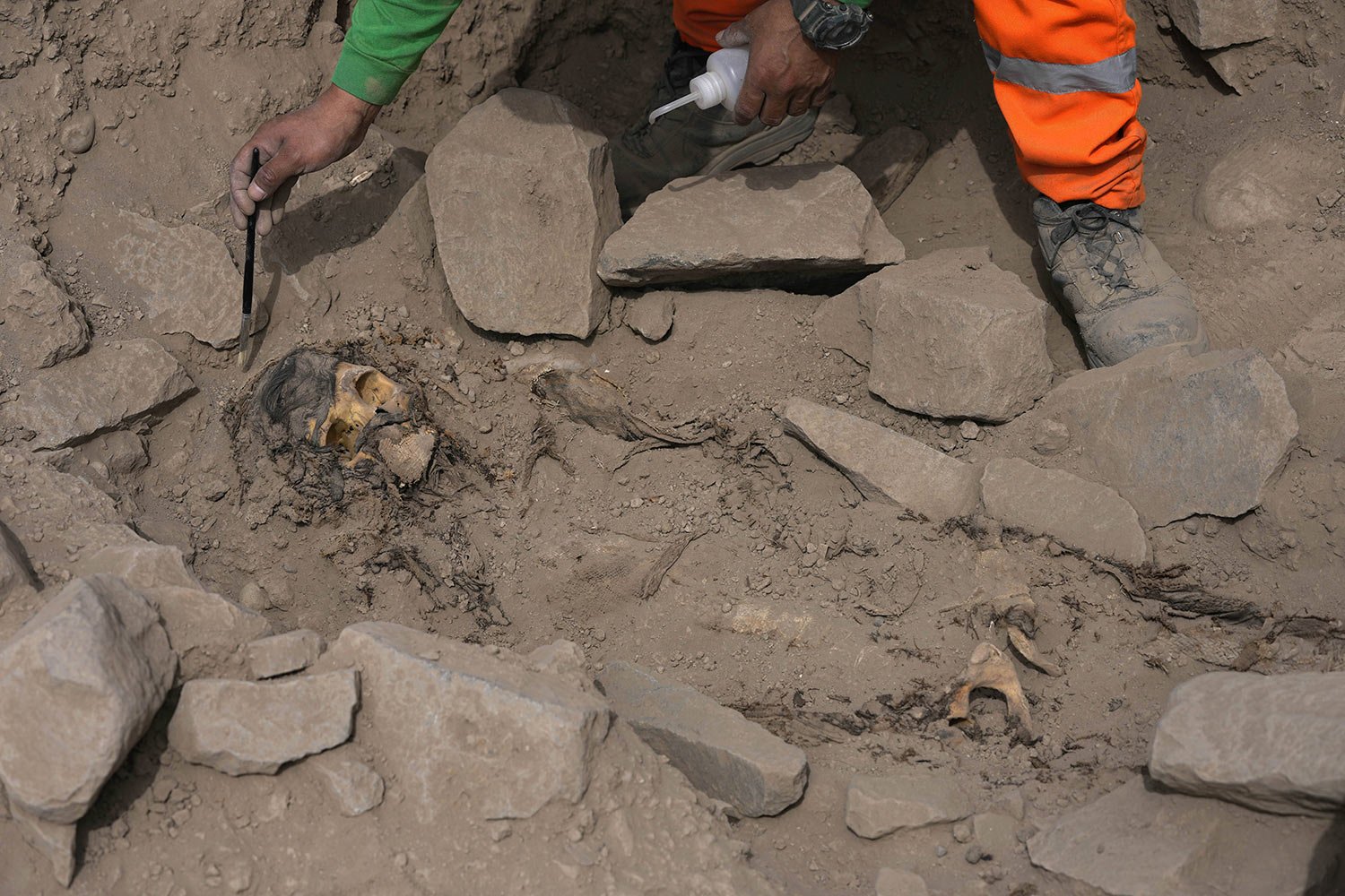  An archaeologist excavates a pre-Hispanic mummy that was discovered next to a training field for a Peruvian professional soccer team in the El Rimac neighborhood of Lima, Peru, June 15, 2023. (AP Photo/Martin Mejia) 