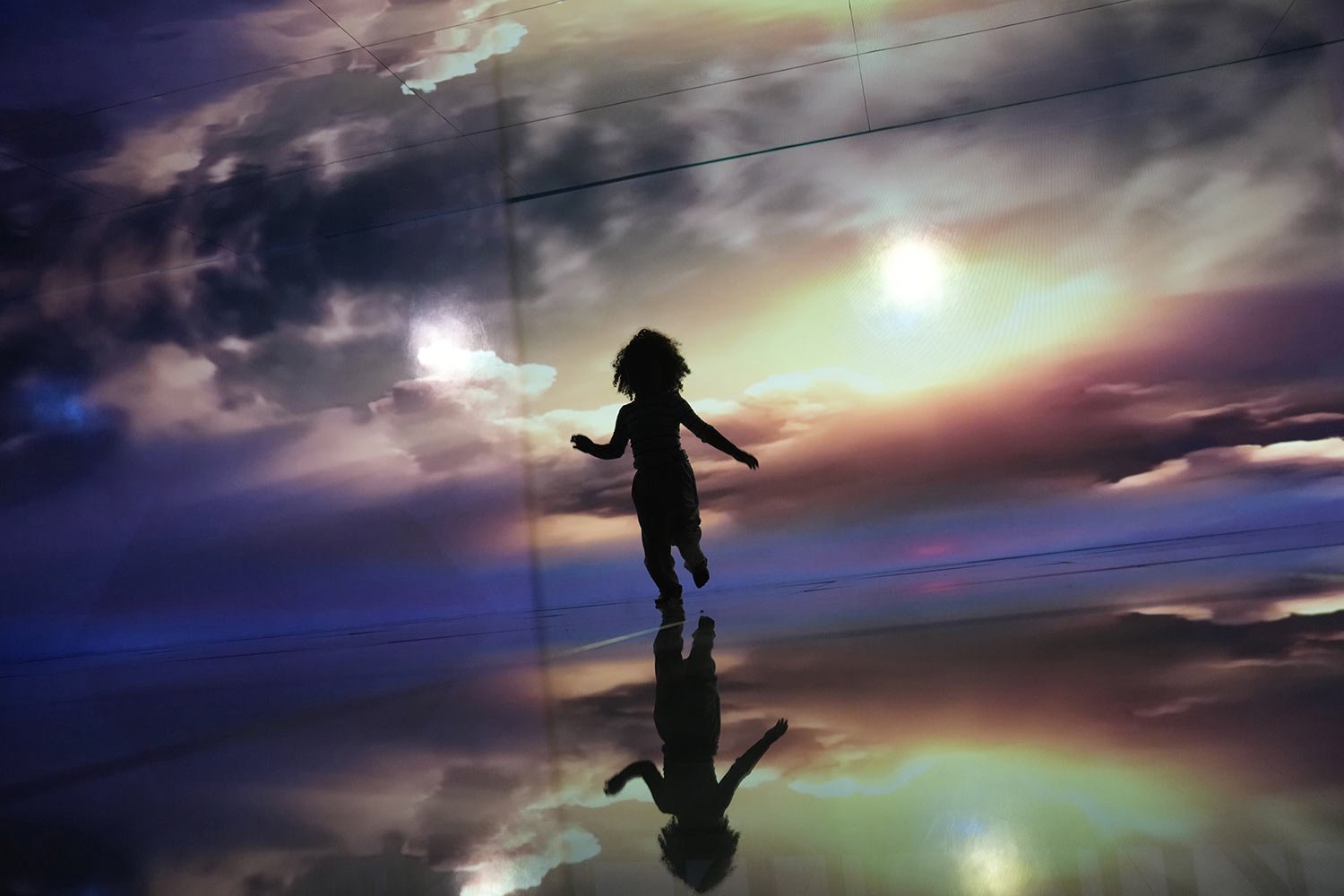A child runs through a mirror installation titled Sea of Mirrors, featuring digital images of horizons, oceans and rivers, during a preview tour the day before the show's public opening at the AquaRio aquarium in Rio de Janeiro, Brazil, June 14, 202