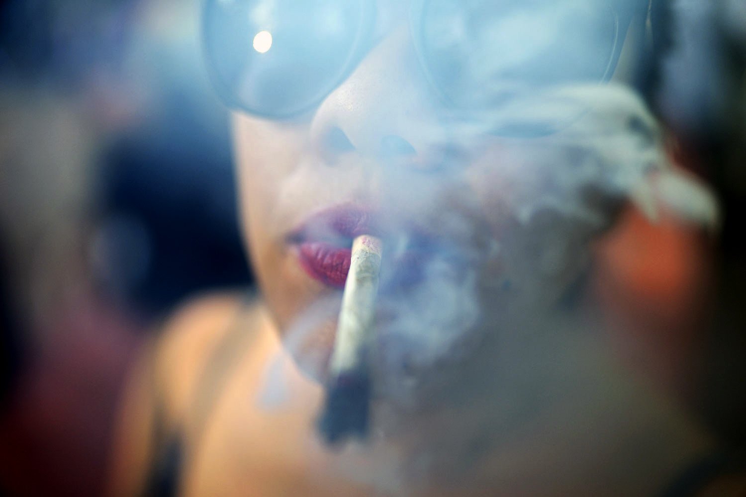 A youth smokes marijuana during the Open Plaza festival organized by the Granjamadre marijuana farm, in Asuncion, Paraguay, June 4, 2023. Organizers were affiliating people to found the Cannabic Club of Paraguay. (AP Photo/Jorge Saenz)