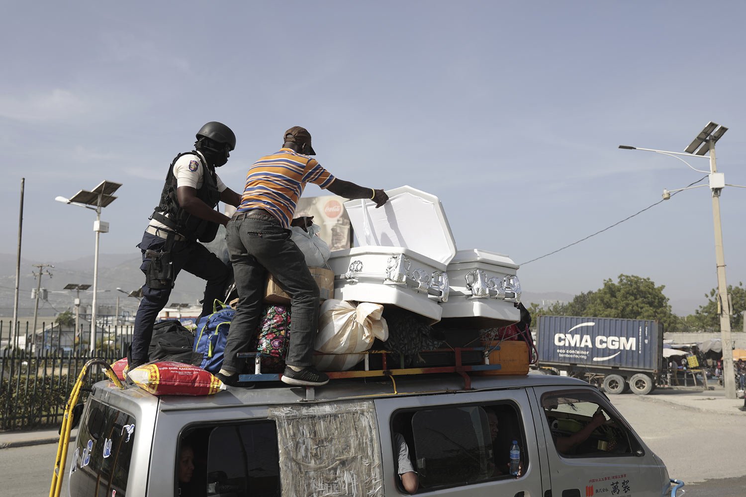  A policeman checks a public transport driver's cargo that includes coffins, in Port-au-Prince, Haiti, Saturday, July 1, 2023. (AP Photo/Odelyn Joseph) 