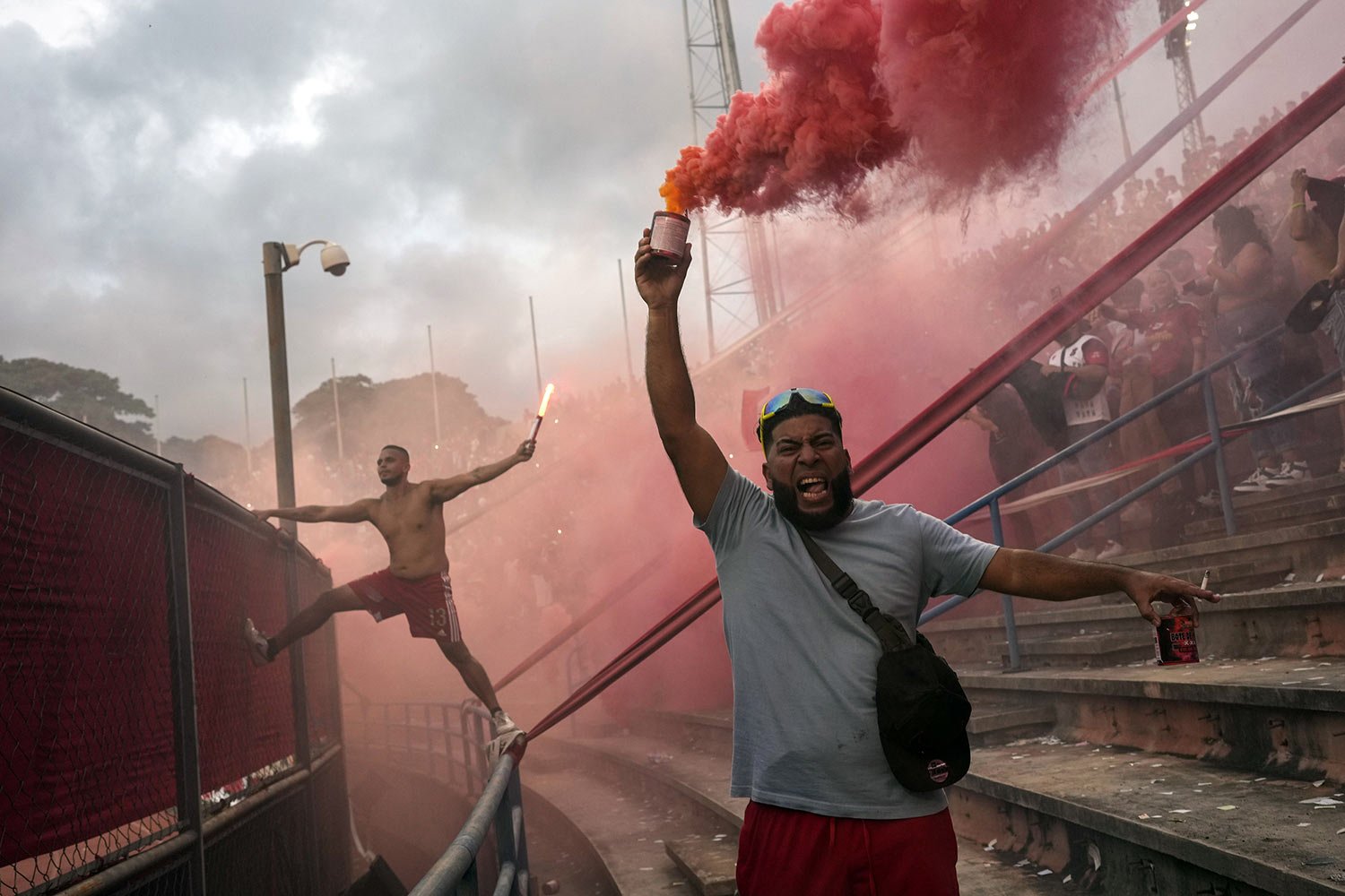  Members of the Caracas FC fan club, who call themselves The Red Demons, light flares during the derby soccer match against Deportivo Tachira at Estadio Olimpico in Caracas, Venezuela, Sunday, July 23, 2023. (AP Photo/Matias Delacroix) 