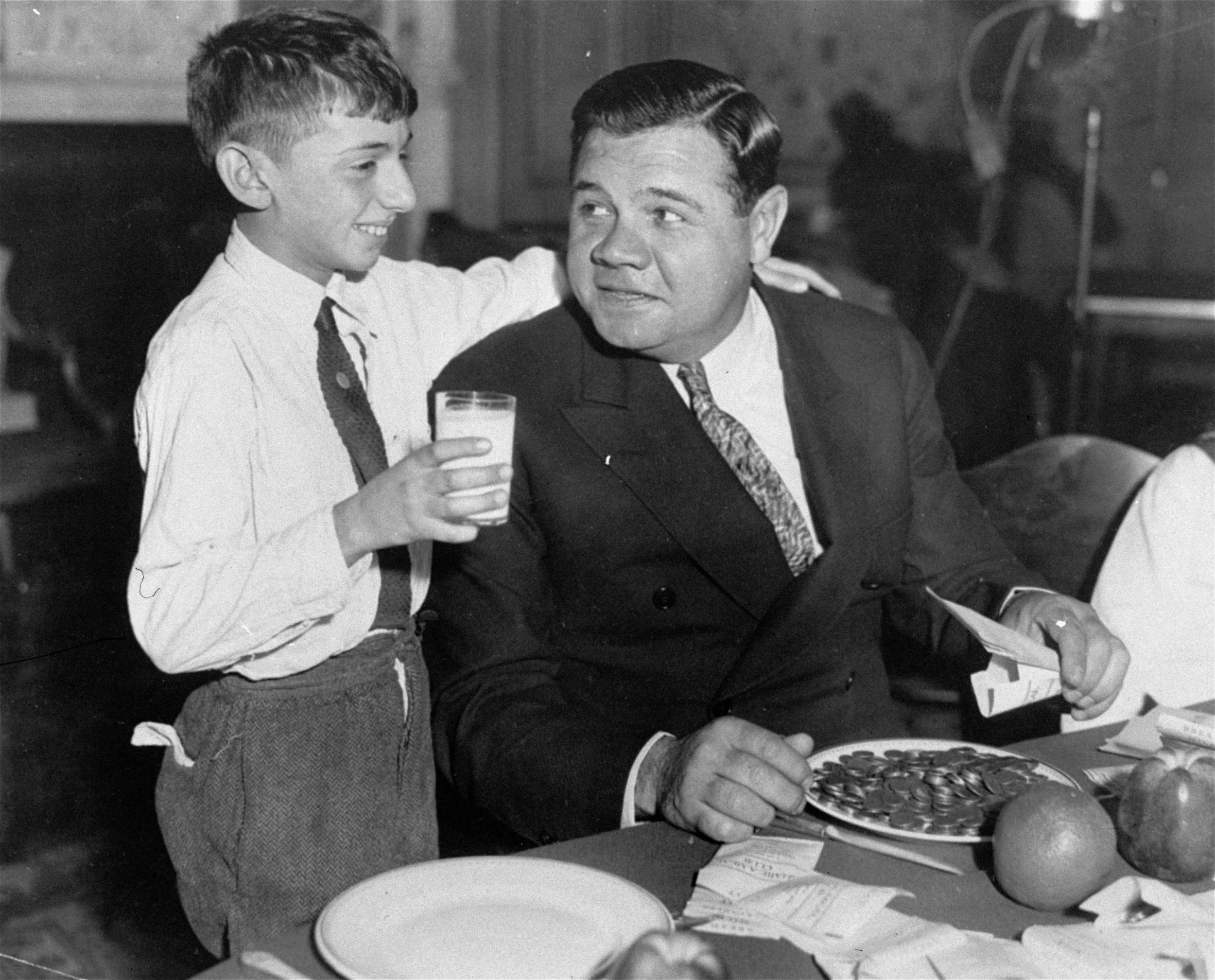  Babe Ruth, the idol of American youth, pictured with a young admirer during a "Share a Meal" club dinner held in New York, Dec. 18, 1932.  The movement, which is made up of boys and girls clubs throughout the city, is seeking to raise as much money 