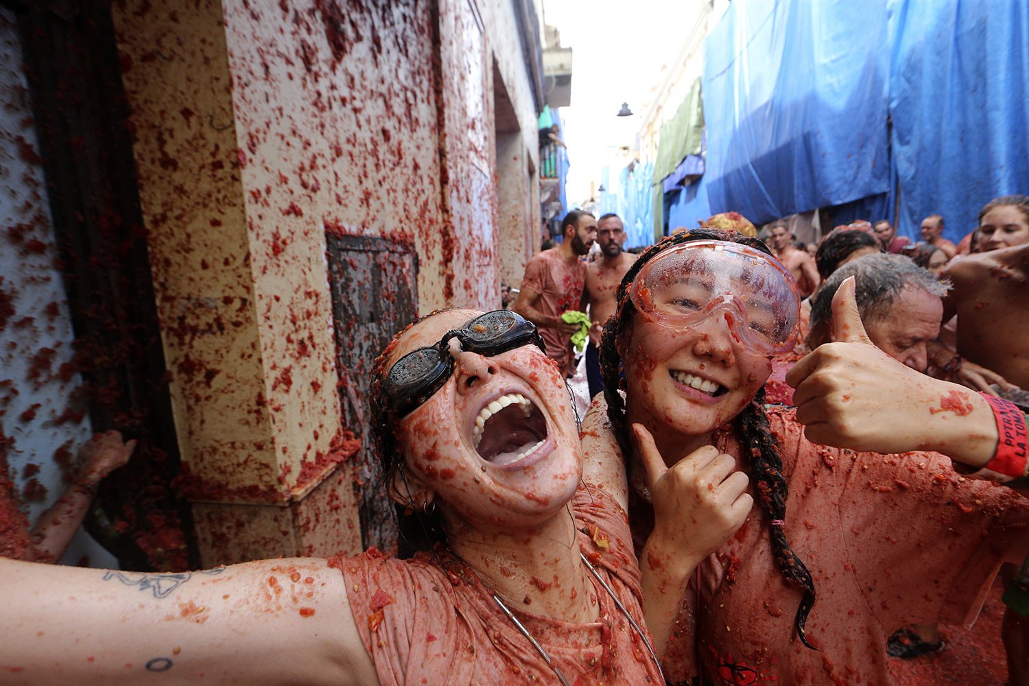  Women drenched with tomato pulp revel amid the annual “Tomatina” street battle , in Bunol, Spain, Wednesday, Aug. 30, 2023. (AP Photo/Alberto Saiz) 
