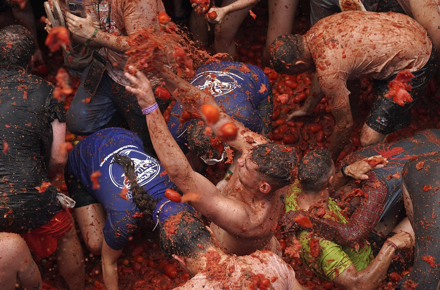  People pelt each other with overripe tomatoes during the the annual "Tomatina" festival, in Bunol, Spain, Wednesday, Aug. 30, 2023. (AP Photo/Alberto Saiz) 