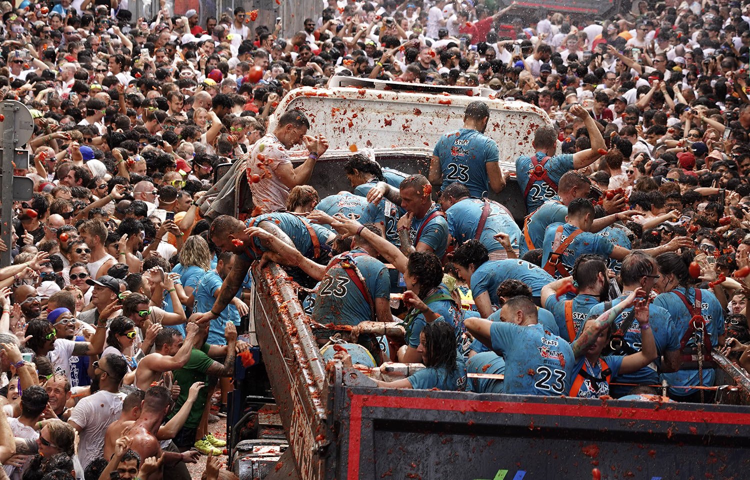  Workers on a truck toss out overripe tomatoes to participants in Bunol, Spain, Wednesday, Aug. 30, 2023. (AP Photo/Alberto Saiz) 