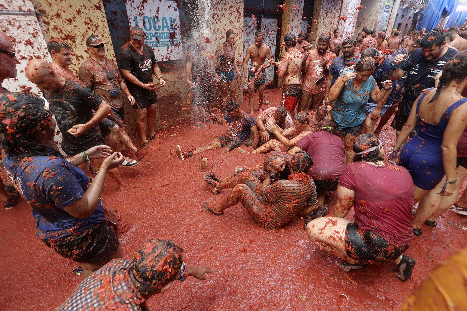  People hurl tomatoes at each other during the annual tomato street fight in Bunol, Spain, Wednesday, Aug. 30, 2023. (AP Photo/Alberto Saiz) 