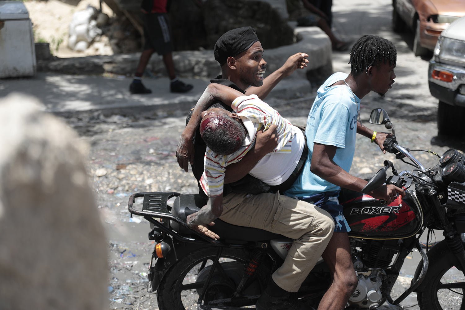  A police officer holds a person who was shot in the head during violent gang clashes, on a moto-taxi in the Carrefour-Feuilles district of Port-au-Prince, Haiti, Aug. 15, 2023. (AP Photo/ Odelyn Joseph) 