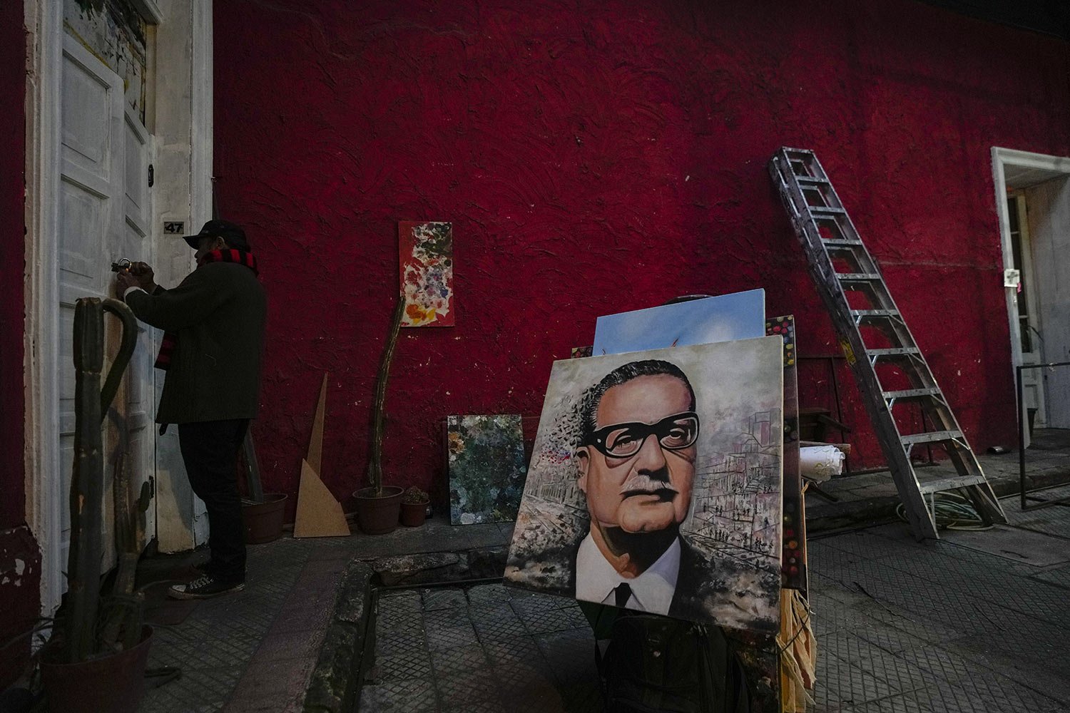  Painter Efren Cortes opens the door of his workshop after transporting his paintings, including one of the late President Salvador Allende, on a dolly from the Plaza de Armas, where he has been selling his paintings for over 30 years in Santiago, Ch