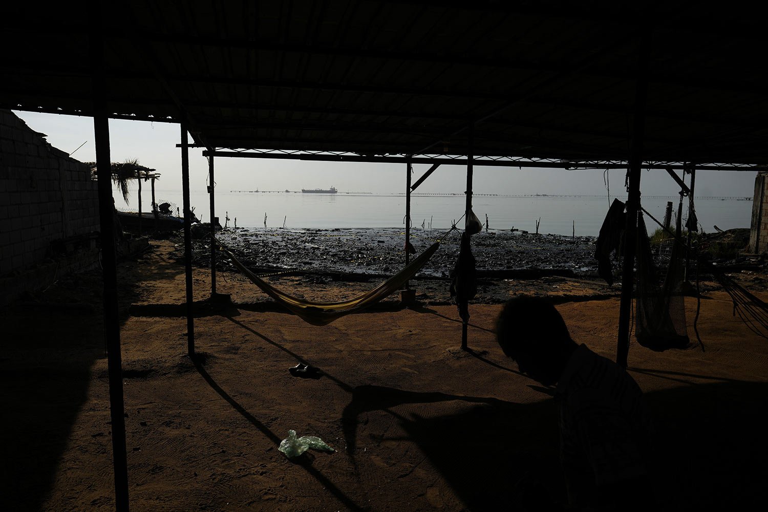  Thatched roof huts line the shore of Lake Maracaibo contaminated with oil and aquatic trash, in San Francisco, Venezuela, Aug. 9, 2023. (AP Photo/Ariana Cubillos) 