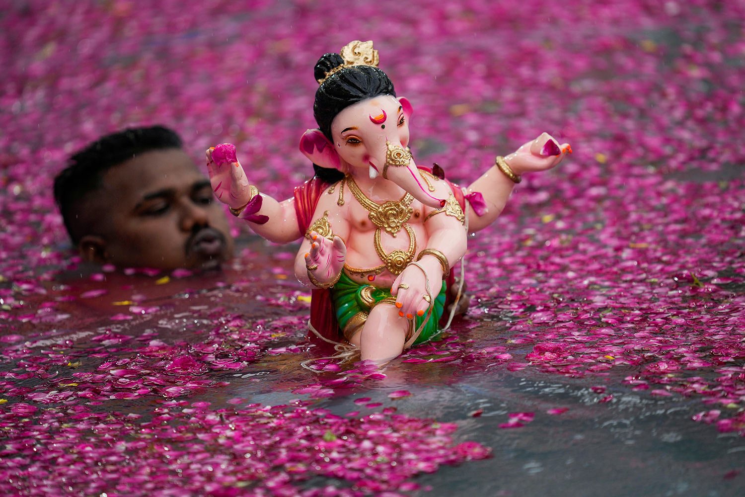  A man prepares to immerse in an artificial pond, an idol of elephant headed Hindu god Ganesha on the second day of ten days long Ganesh Chaturthi festival in Mumbai, India, Wednesday, Sept. 20, 2023. (AP Photo/Rajanish Kakade) 