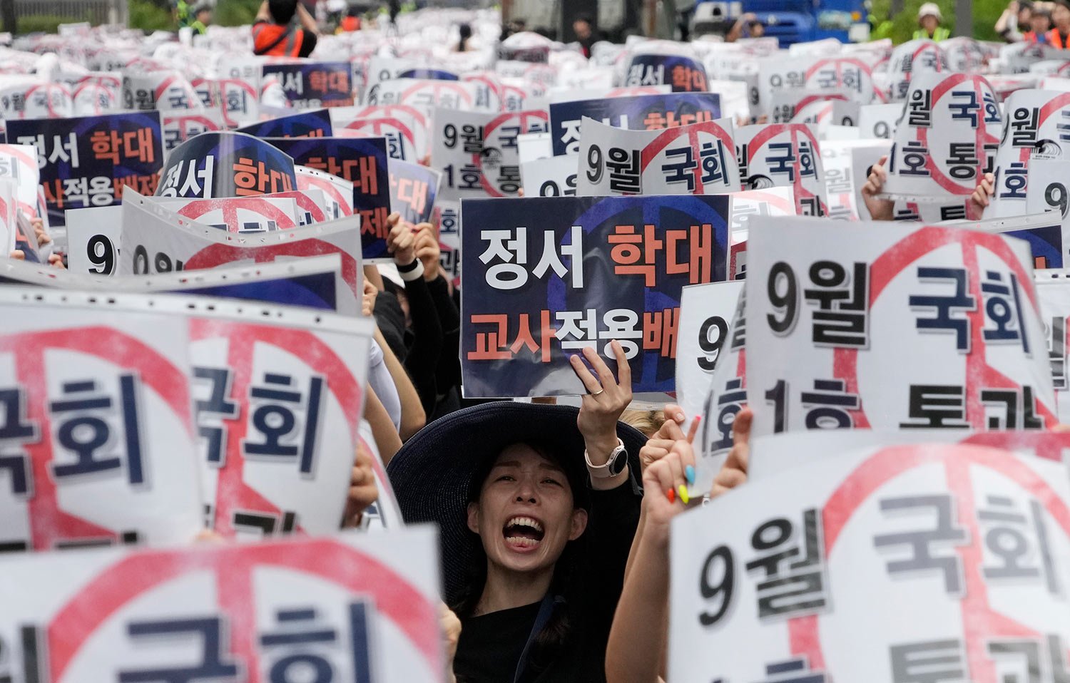  A teacher shouts slogans during a rally to demand better protection of their rights near the National Assembly in Seoul, South Korea, Saturday, Sept. 16, 2023.  The sign reads "Grant teachers immunity from child emotional abuse claims." (AP Photo/Ah