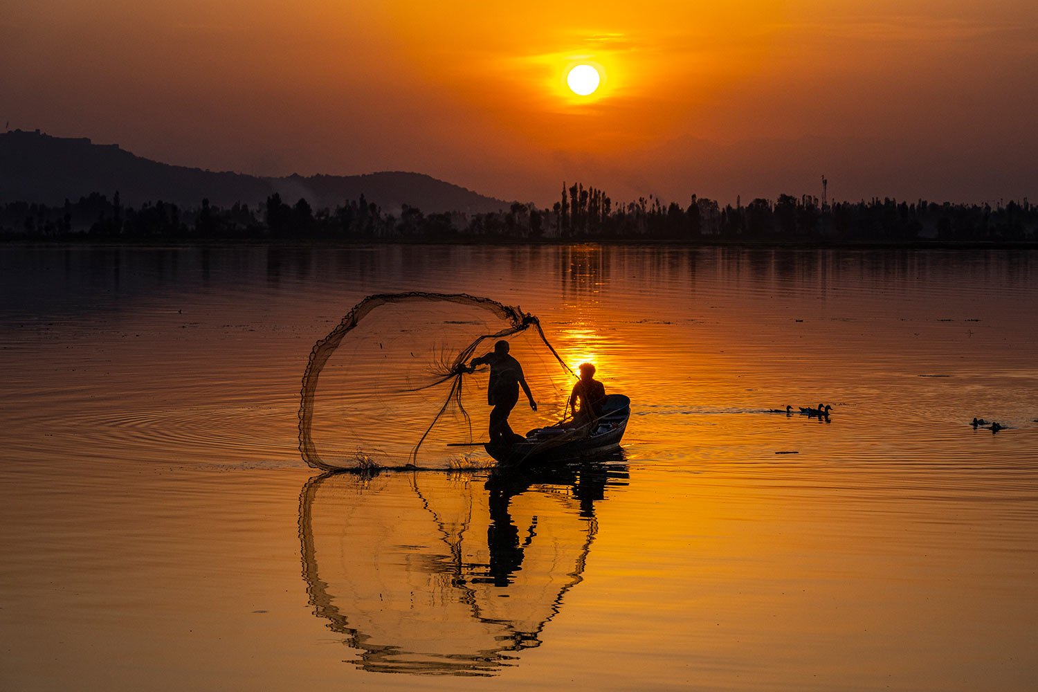  A Kashmiri fisherman casts his net during sunset on the Dal Lake in Srinagar, Indian controlled Kashmir, Friday, Sept. 1, 2023. (AP Photo/Dar Yasin) 