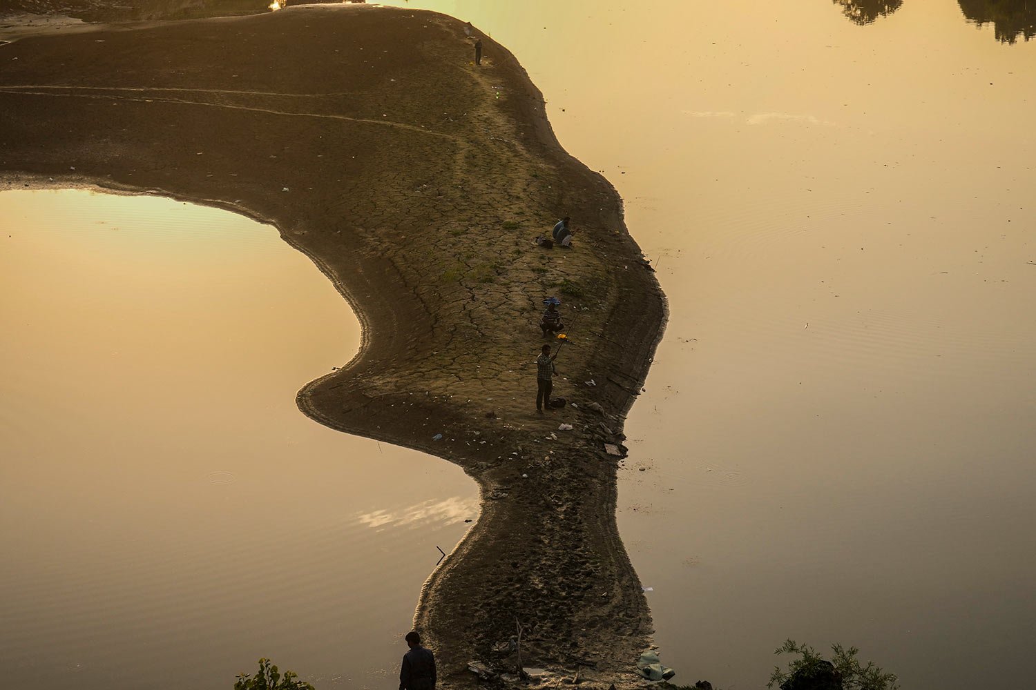  Kashmiris fish in the dried portion of Jhelum river in Srinagar, Indian controlled Kashmir, Wednesday, Sept. 6, 2023. (AP Photo/Mukhtar Khan) 