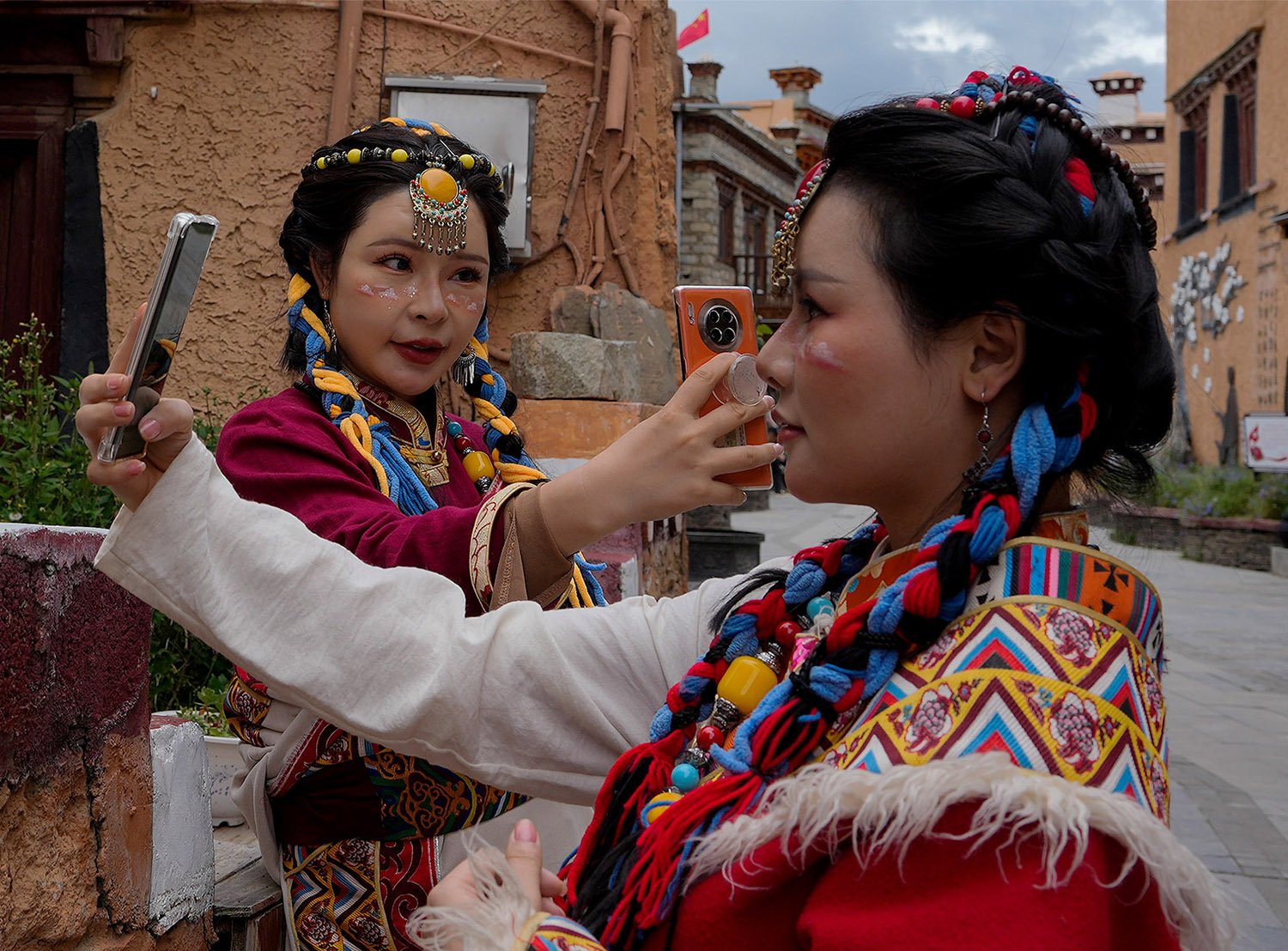  Women wearing Tibetan costumes take selfies as they visit the thousand-household Tibetan village, one of the tourism spot in Litang county, Ganzi Tibetan Autonomous Prefecture of southwestern China's Sichuan province, Friday, Sept. 8, 2023. (AP Phot