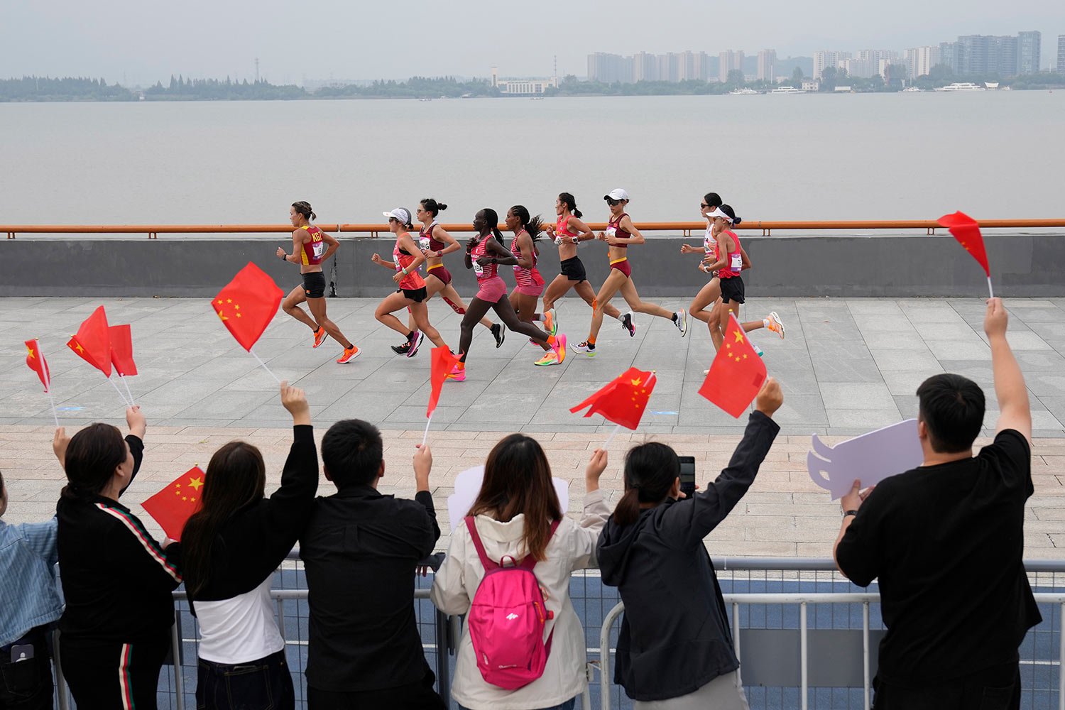  Spectators cheer as runners compete during the women's marathon at the 19th Asian Games in Hangzhou, China, Thursday, Oct. 5, 2023. (AP Photo/Aijaz Rahi) 