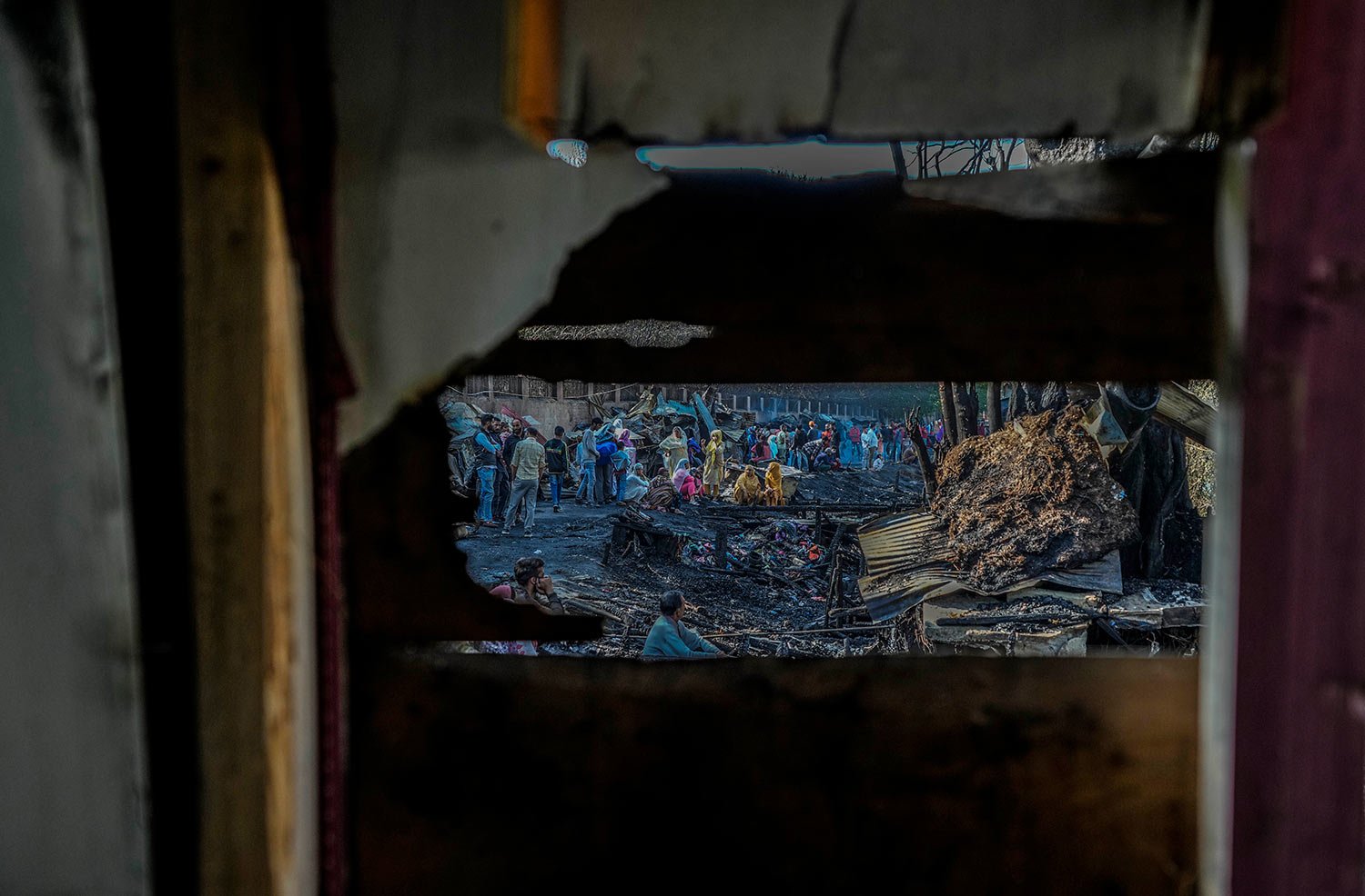  People look at debris after a fire gutted nearly a dozen shanties on the outskirts of Srinagar, Indian-controlled Kashmir, Sunday, Oct. 1, 2023.  (AP Photo/Mukhtar Khan) 