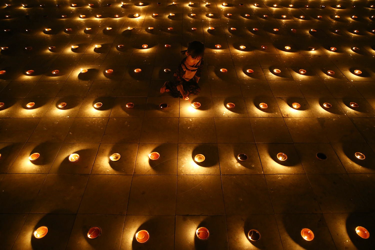  A Buddhist devotee lights oil lamps during celebrations of the full moon day of Thadingyut, or lighting festival, to mark the end of Buddhist Lent, Sunday, Oct. 29, 2023, in Naypyitaw, Myanmar. (AP Photo/Aung Shine Oo) 