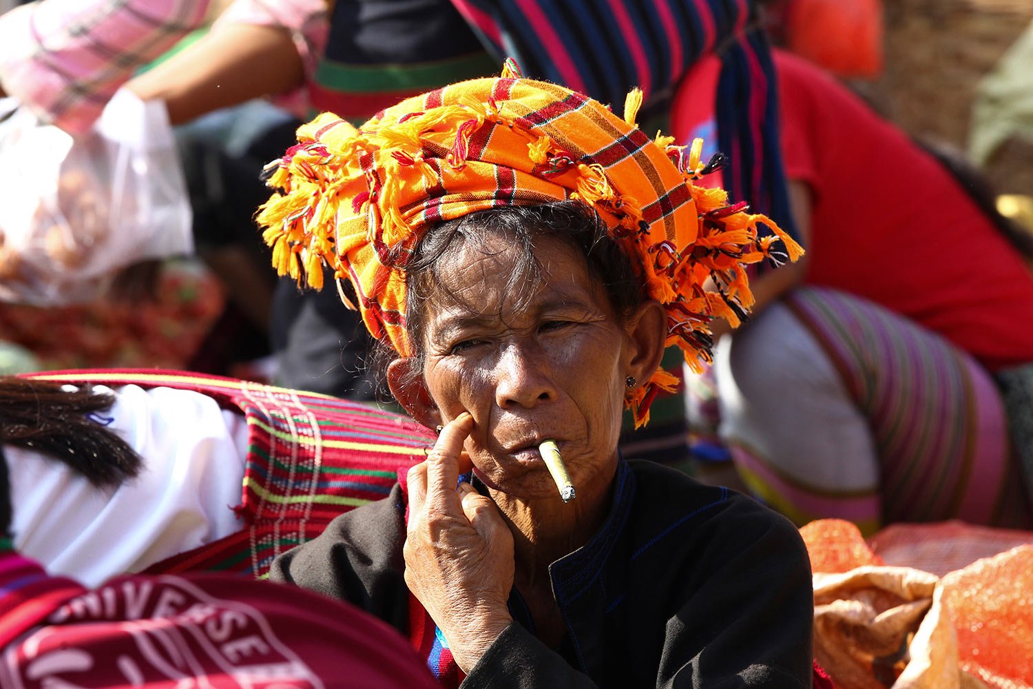  A Pa-O ethnic woman smokes a cigar as she waits for customers at a local bazaar Friday, Oct. 20, 2023, in Inle Lake, southern Shan State, Myanmar. (AP Photo/Thein Zaw) 