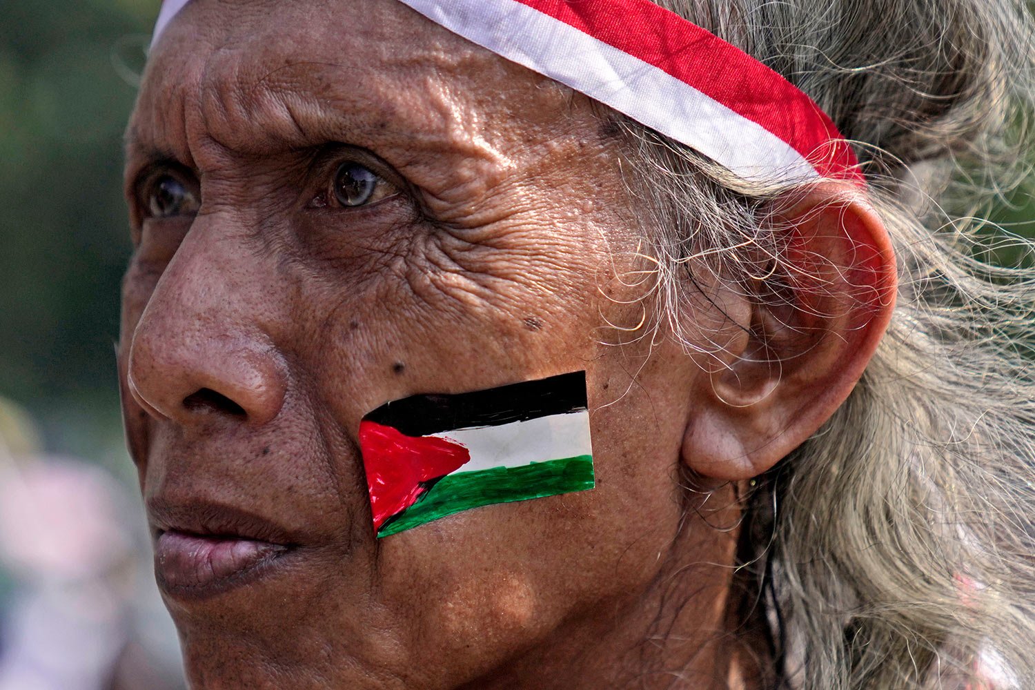  A man wears a sticker of Palestinian flag during a rally in support of the Palestinians in Jakarta, Indonesia, Friday, Oct. 13, 2023.(AP Photo/Dita Alangkara) 