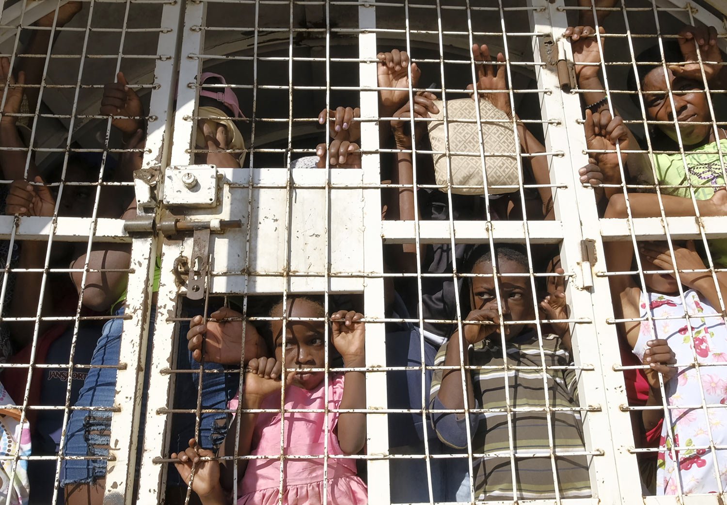  Haitians detained for deportation stand in a police truck on a border bridge between Dajabon, Dominican Republic, and Haiti, Oct. 11, 2023. The D.R. partially reopened its border with Haiti to limited commercial activity nearly a month after shutter