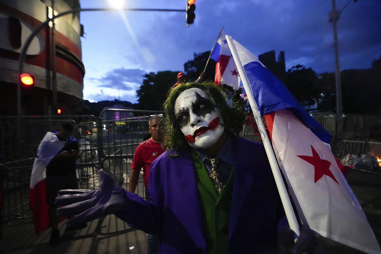  A demonstrator dressed as the comic book character The Joker, holds a Panamanian flag during a protest against a mining contract between the government and Canadian mining company First Quantum, in Panama City, Oct. 31, 2023. (AP Photo/Arnulfo Franc