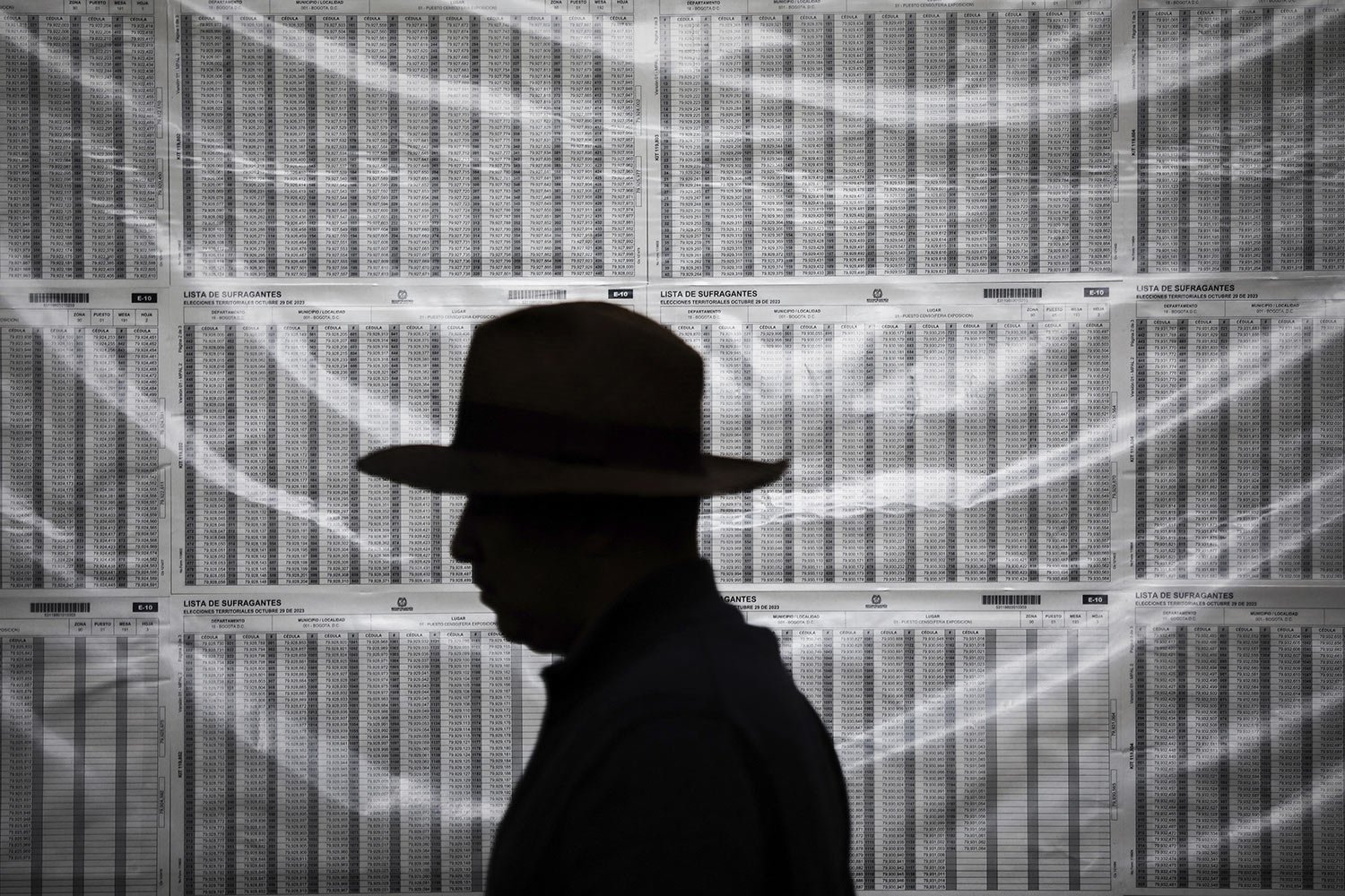  A voter walks past electoral lists during elections in Bogota, Colombia, Oct. 29, 2023. (AP Photo/Ivan Valencia) 