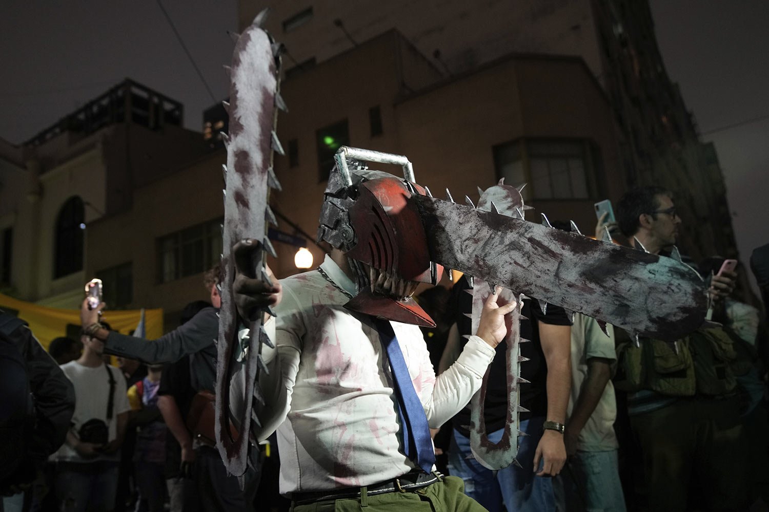  A supporter of presidential candidate Javier Milei wears a chainsaw mask outside his campaign headquarters after polls closed for general elections in Buenos Aires, Argentina, Oct. 22, 2023. (AP Photo/Mario De Fina) 