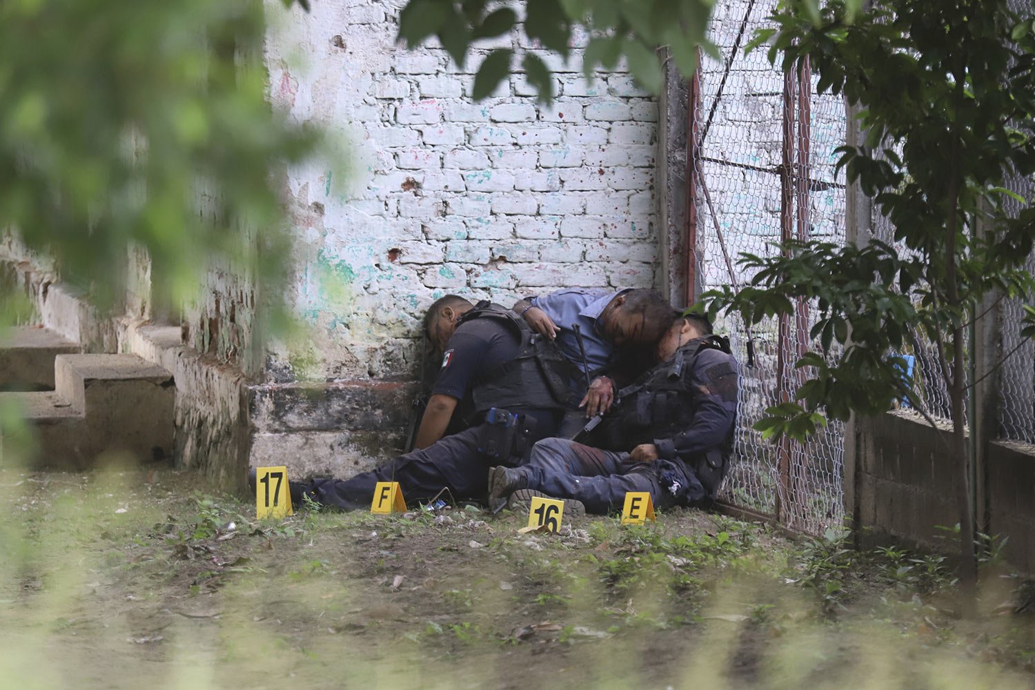  The bodies of slain police officers are slumped against a wall in El Papayo, Coyuca de Benitez municipality, Guerrero state, Mexico, Oct. 23, 2023. Twelve police officers and their boss were gunned down, according to Guerrero state prosecutor's offi