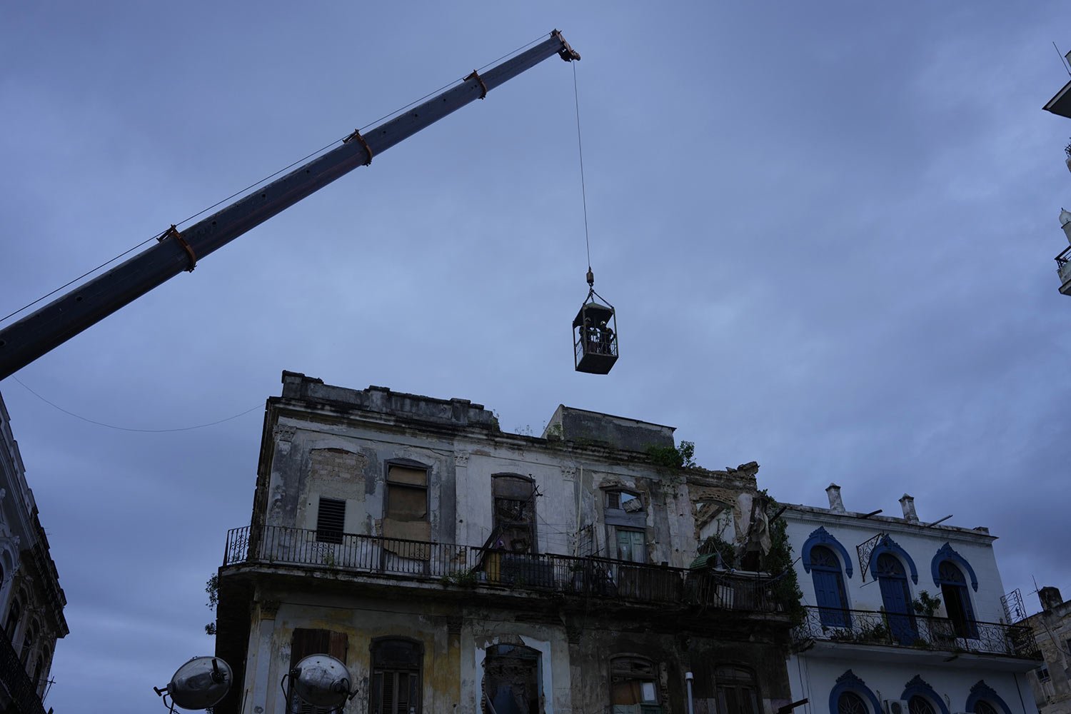  A crane lifts firefighters in a cage toward a building in search of survivors after it partially collapsed in Havana, Cuba, Oct. 4, 2023. (AP Photo/Ramon Espinosa) 