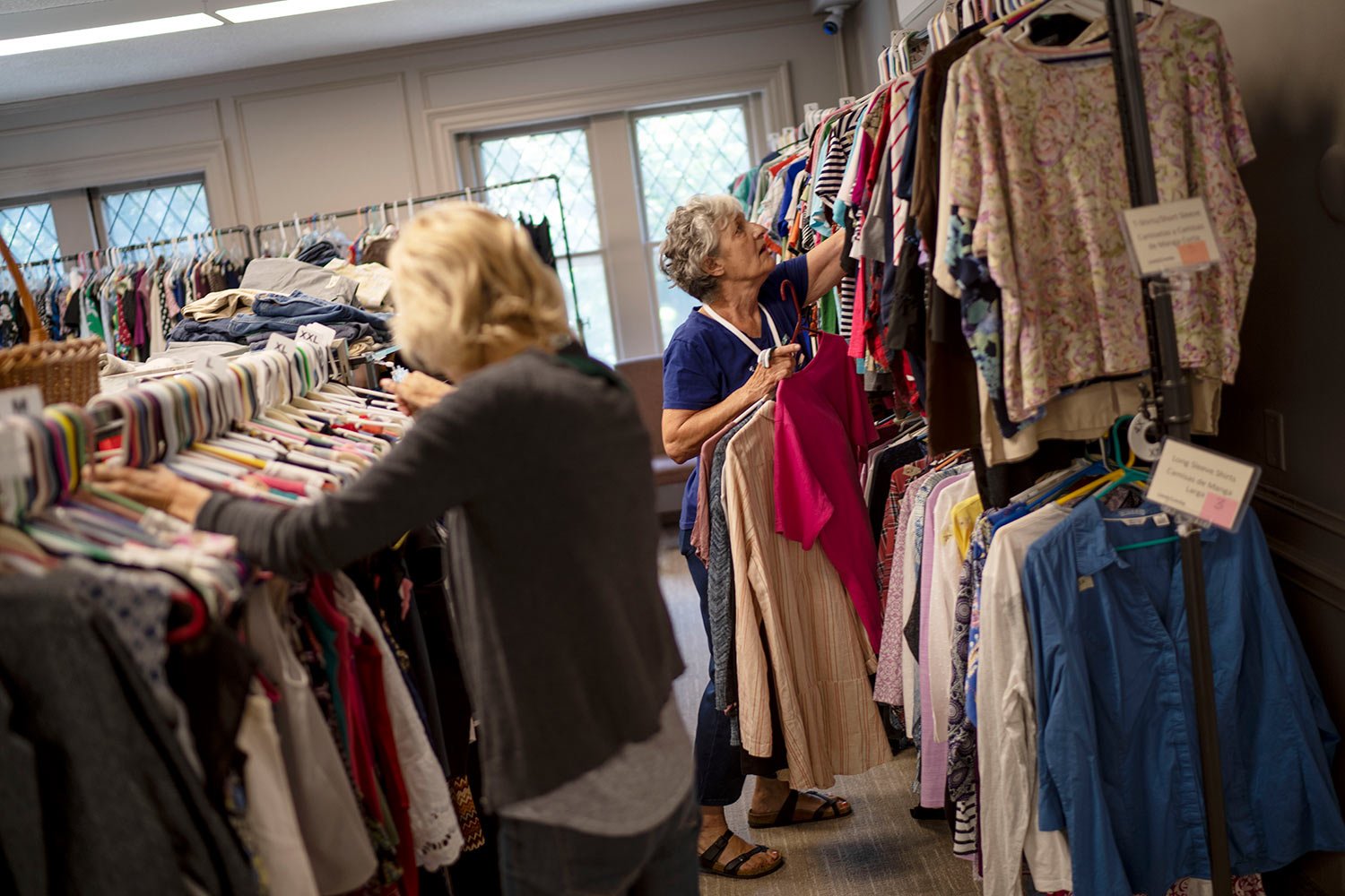  Volunteers Katherine Flynn, right, and Enid Schaefer stock donated clothes on a rack in the community outreach center at Asbury First United Methodist Church, Tuesday, Aug. 22, 2023, in Rochester, N.Y. (AP Photo/David Goldman)  