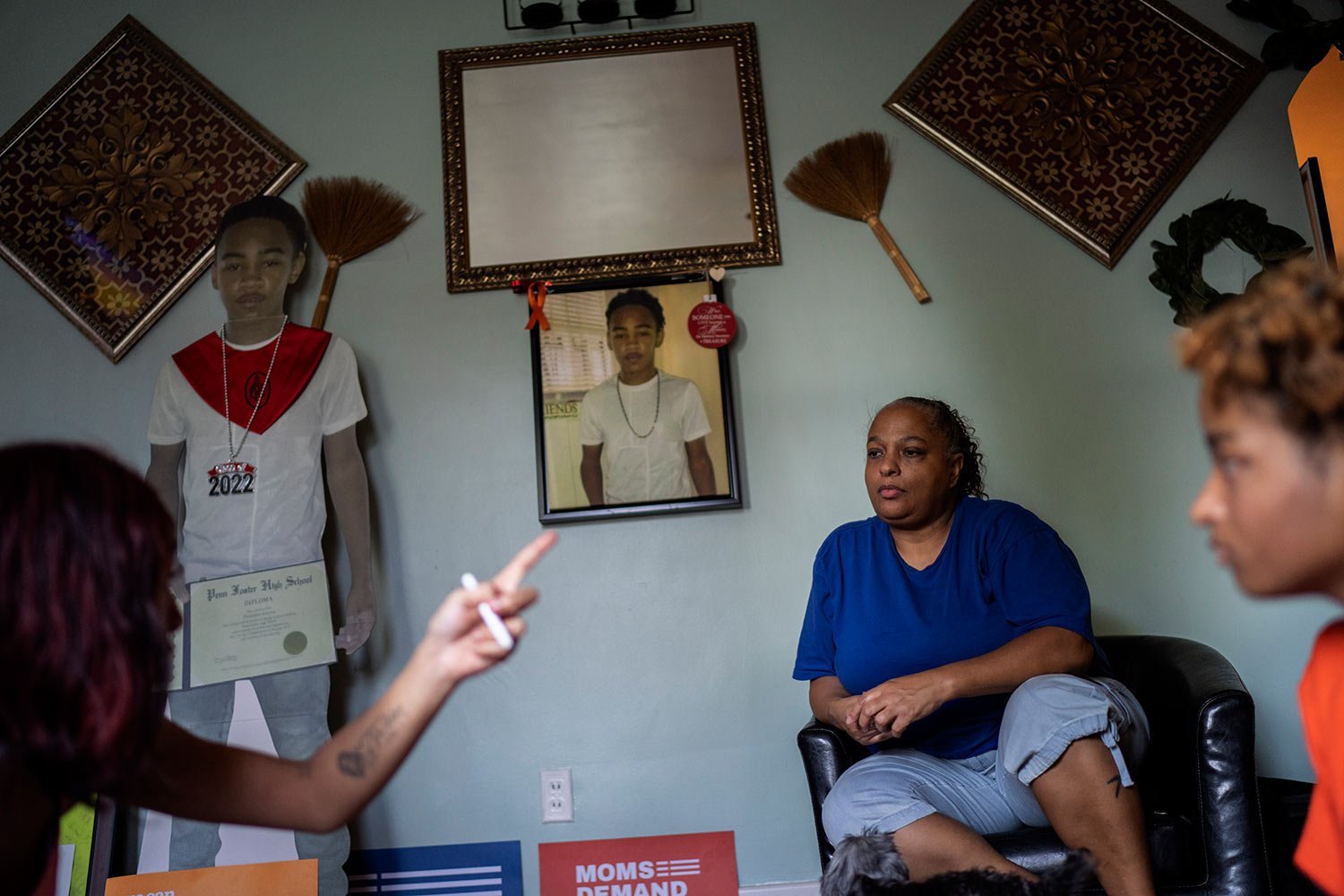  A life-size cutout of Christian Gwynn, along with a portrait of him, decorate his home as his mother, Krista, center, and sisters Victoria, 21, left, and Navada, 15, talk in the living room in Louisville, Ky., Monday, Aug. 28, 2023. (AP Photo/David 