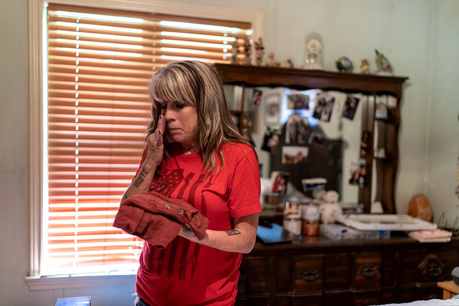  Barbie Rohde wipes away a tear Friday, June 9, 2023 at her home in Flint, Texas, as she holds the T-shirt of her son, Army Sgt. Cody Bowman, who took his own life. (AP Photo/David Goldman)  