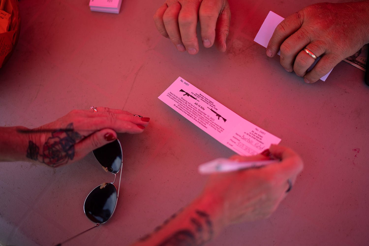  Barbie Rohde, buys a raffle ticket to win an AR-15 rifle at a festival while volunteering for Mission-22, a nonprofit that aims to end military and veteran suicide, Saturday, June 10, 2023, in Jacksonville, Texas. (AP Photo/David Goldman)  