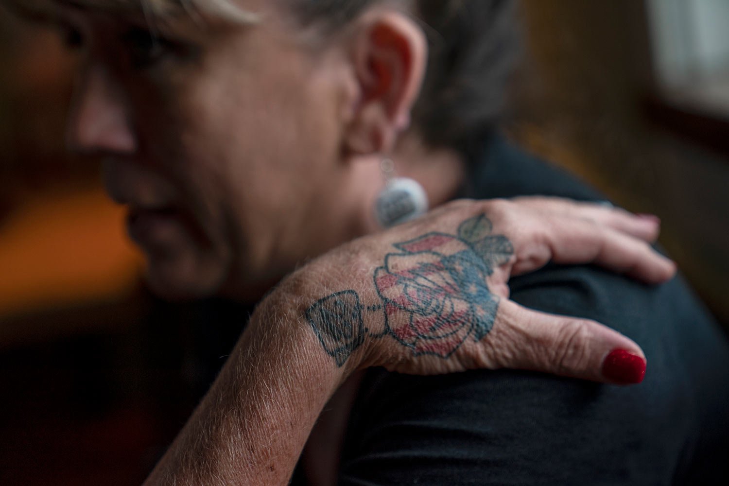  A tattoo of a rose with an American flag decorates the hand of Barbie Rohde, as she sits in a restaurant Saturday, June 10, 2023, in Jacksonville, Texas.  (AP Photo/David Goldman)  