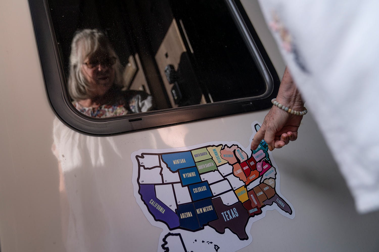  Sandy Phillips is reflected in her RV window as she looks at the states she and her husband, Lonnie, traveled to while visiting mass shootings across the country, as the RV sits in a storage lot in Longmont, Colo., Monday, Sept. 4, 2023. (AP Photo/D