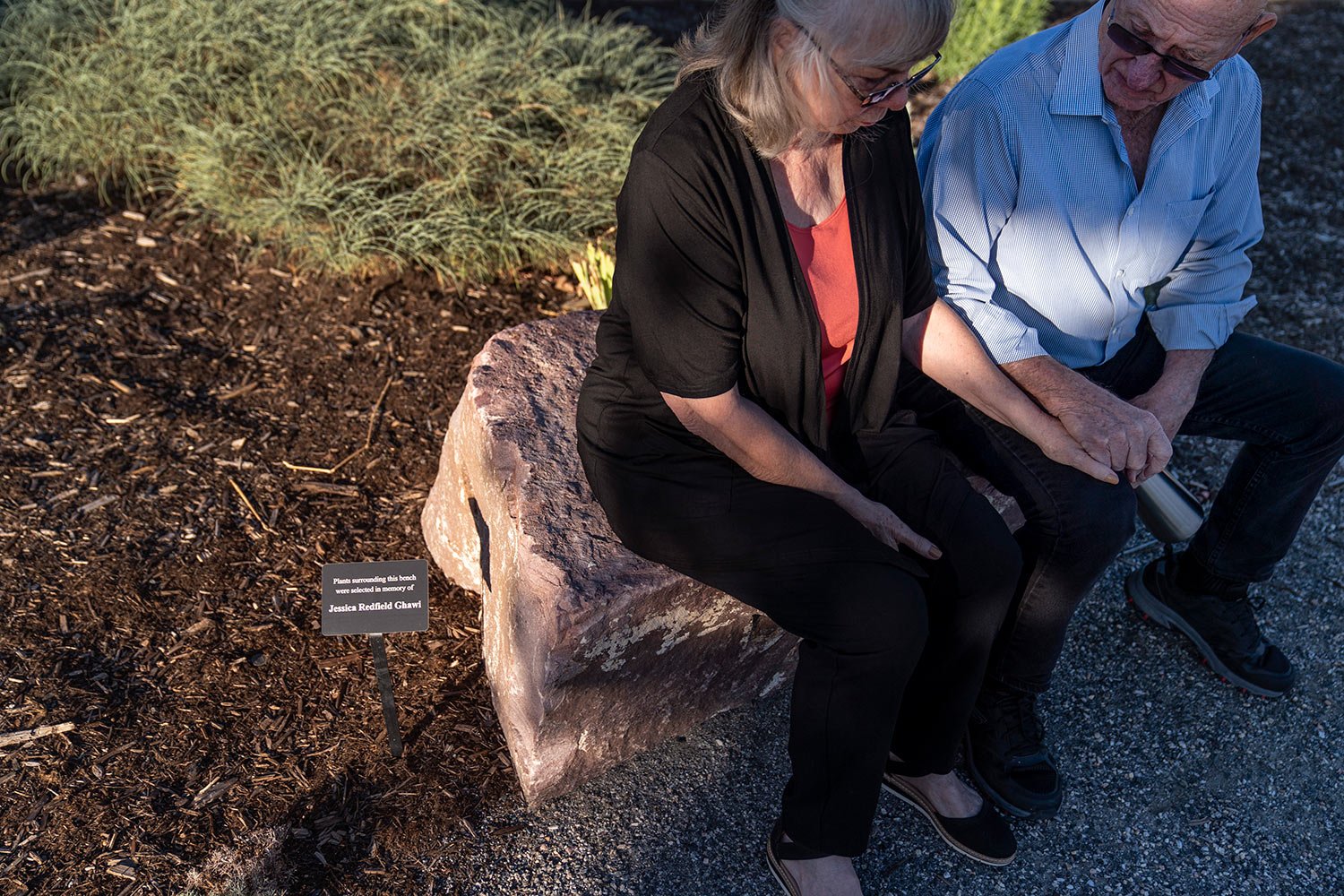  Sandy, left, and Lonnie Phillips, sit on a rock dedicated to Sandy’s daughter, Jessica Ghawi, one of 12 killed in the 2012 mass shooting at an Aurora, Colorado movie theater, as they visit a memorial to the victims Tuesday, Sept. 5, 2023, in Aurora,