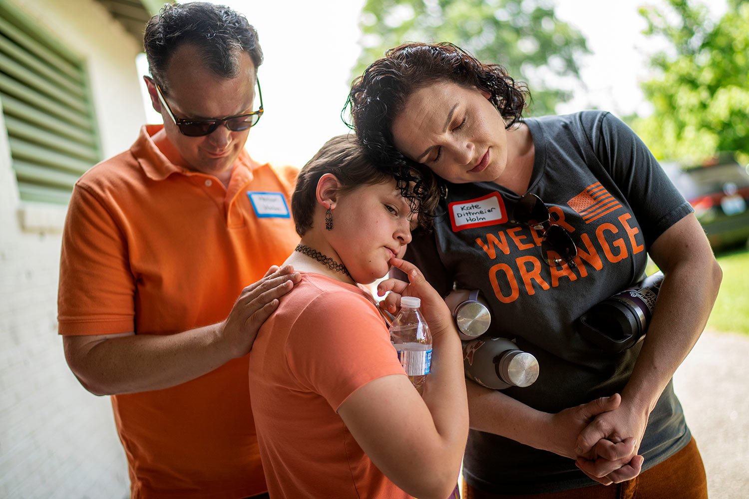  Hollan Holm, left, and his wife Kate Dittmeier Holm, right, observe a moment of silence with their daughter, Sylvia, 11, during a rally against gun violence in Louisville, Ky., Saturday, June 3, 2023. (AP Photo/David Goldman)  