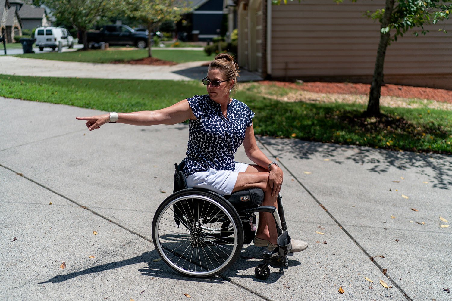  Janet Paulsen points to where she lay in her driveway after her estranged husband shot her six times outside their Acworth, Ga. home, Monday, Aug. 7, 2023. (AP Photo/David Goldman)  
