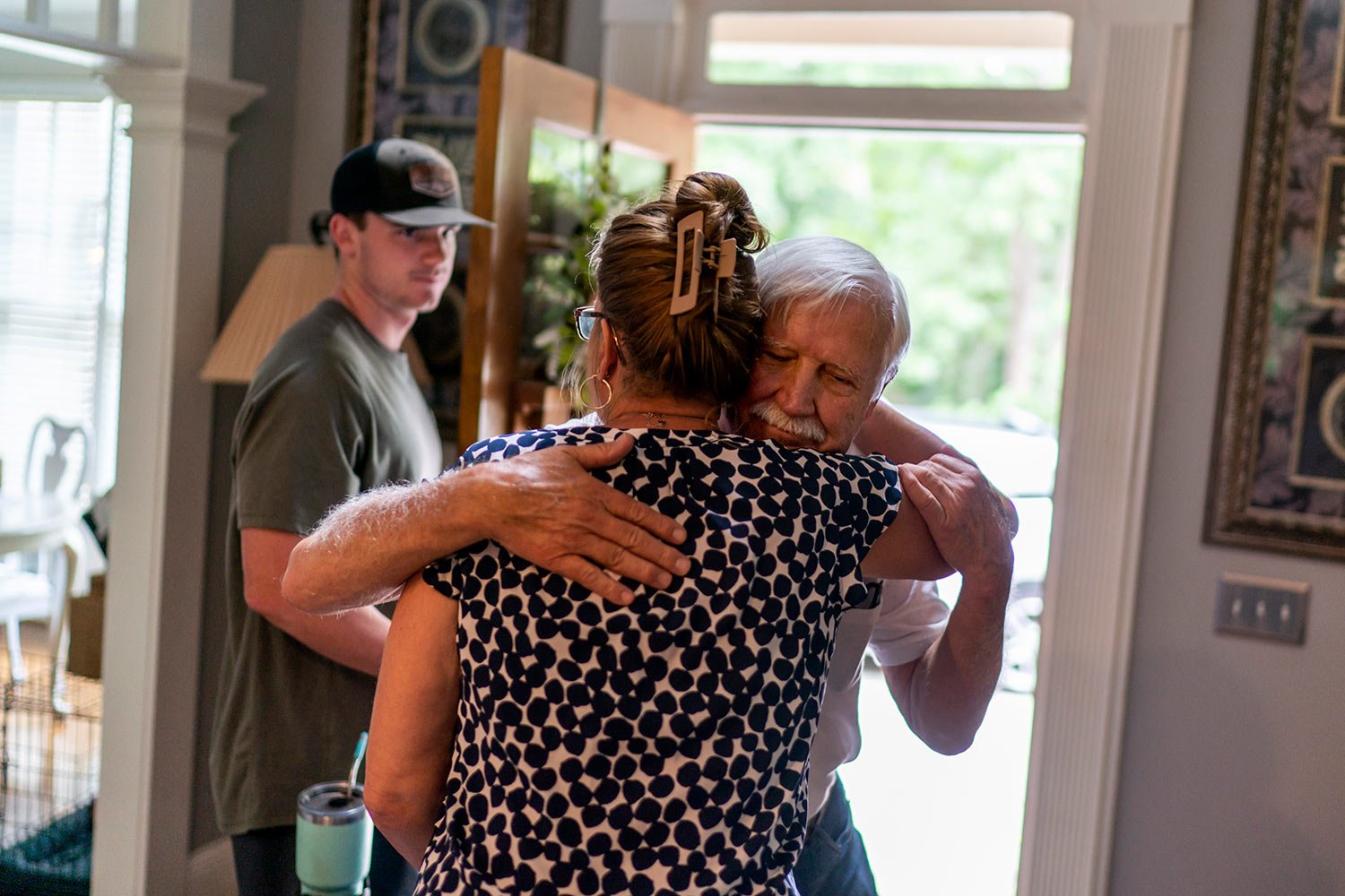  Janet Paulsen hugs her father, Ralph, goodbye as her son, Hunter, 20, looks on in their Acworth, Ga. home, Monday, Aug. 7, 2023. (AP Photo/David Goldman)  
