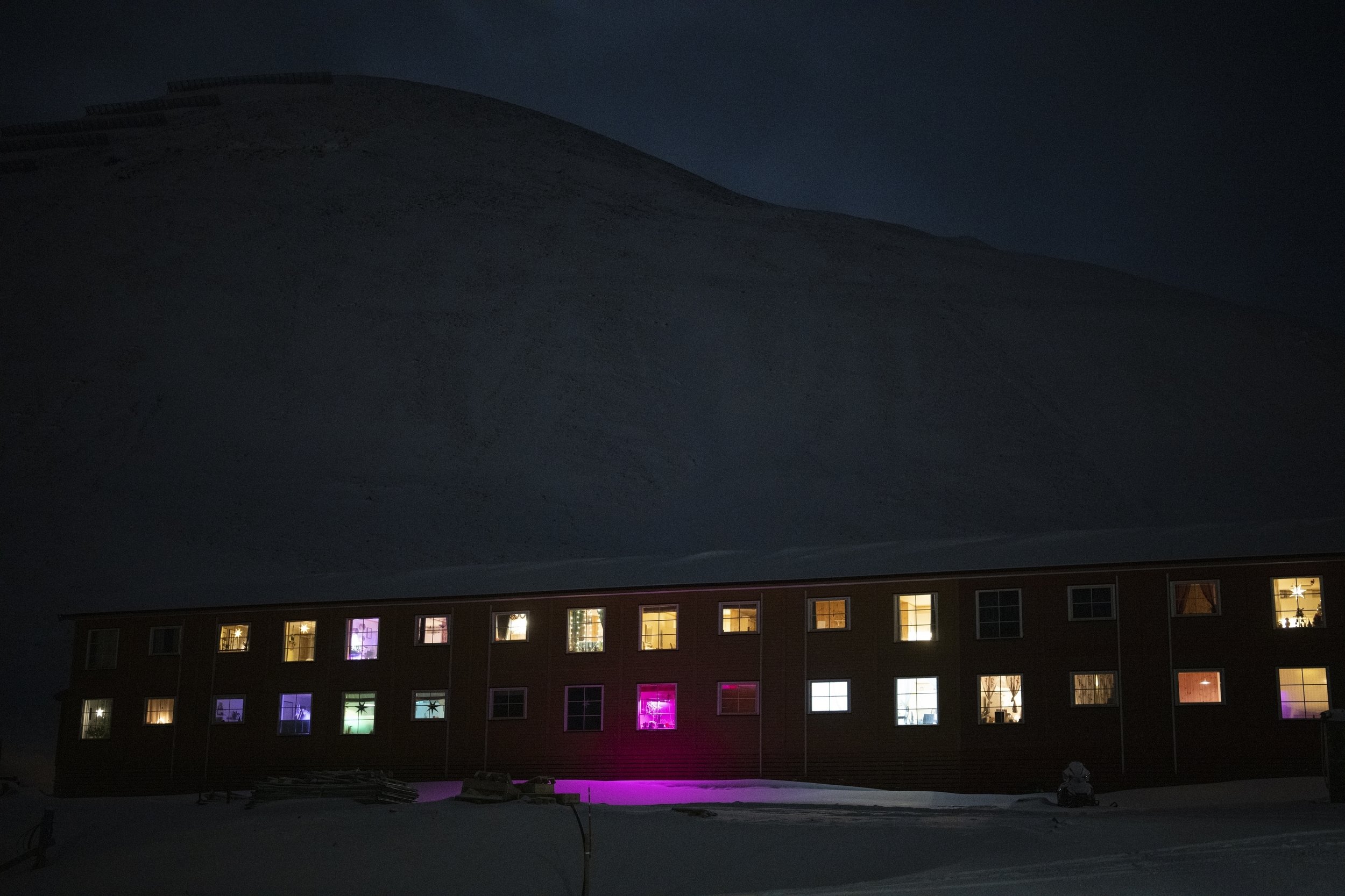  Windows light up the polar night on Jan. 6, 2023, in Longyearbyen, Norway, so close to the North Pole the sun is at least six degrees below the horizon from mid-November through the end of January. (AP Photo/Daniel Cole) 