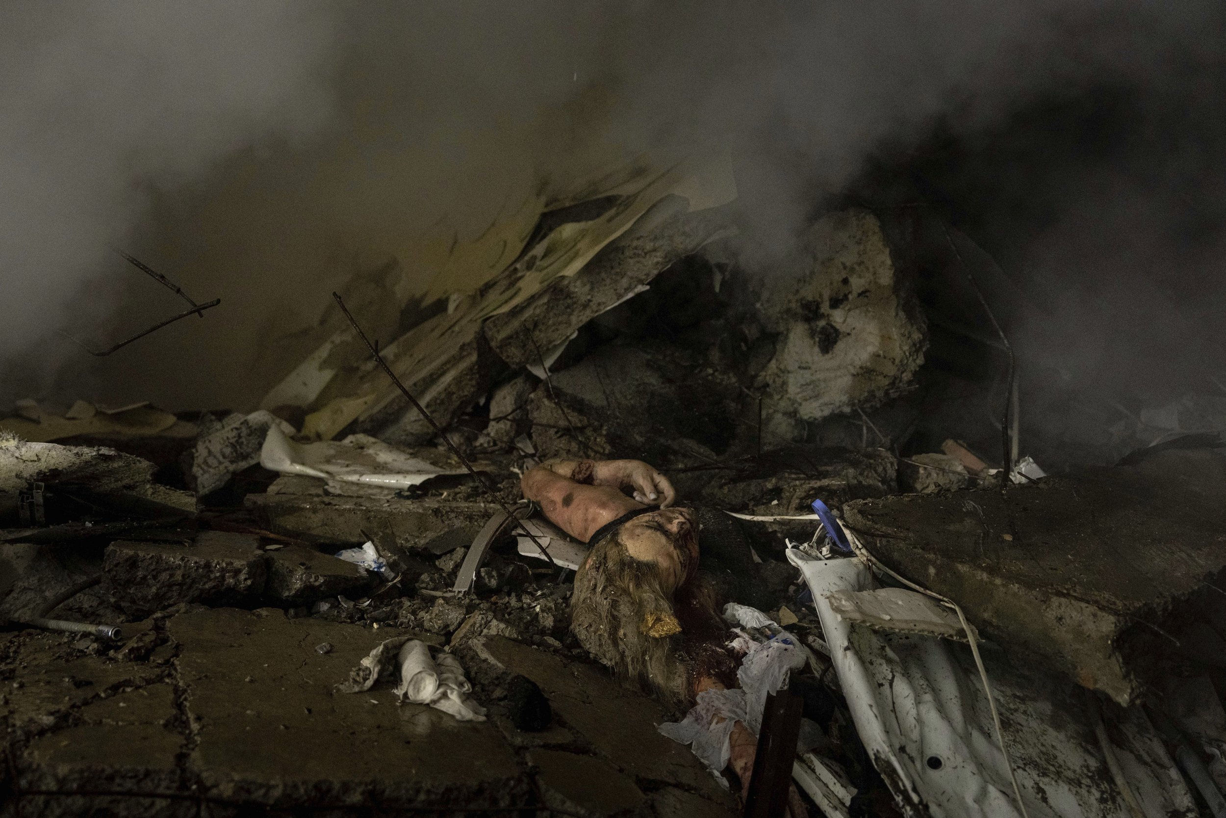  EDS NOTE: GRAPHIC CONTENT - The body of a woman who was killed in a Russian rocket attack on a multistory building lies under rubble in the southeastern city of Dnipro, Ukraine, on Jan. 14, 2023. (AP Photo/Evgeniy Maloletka) 