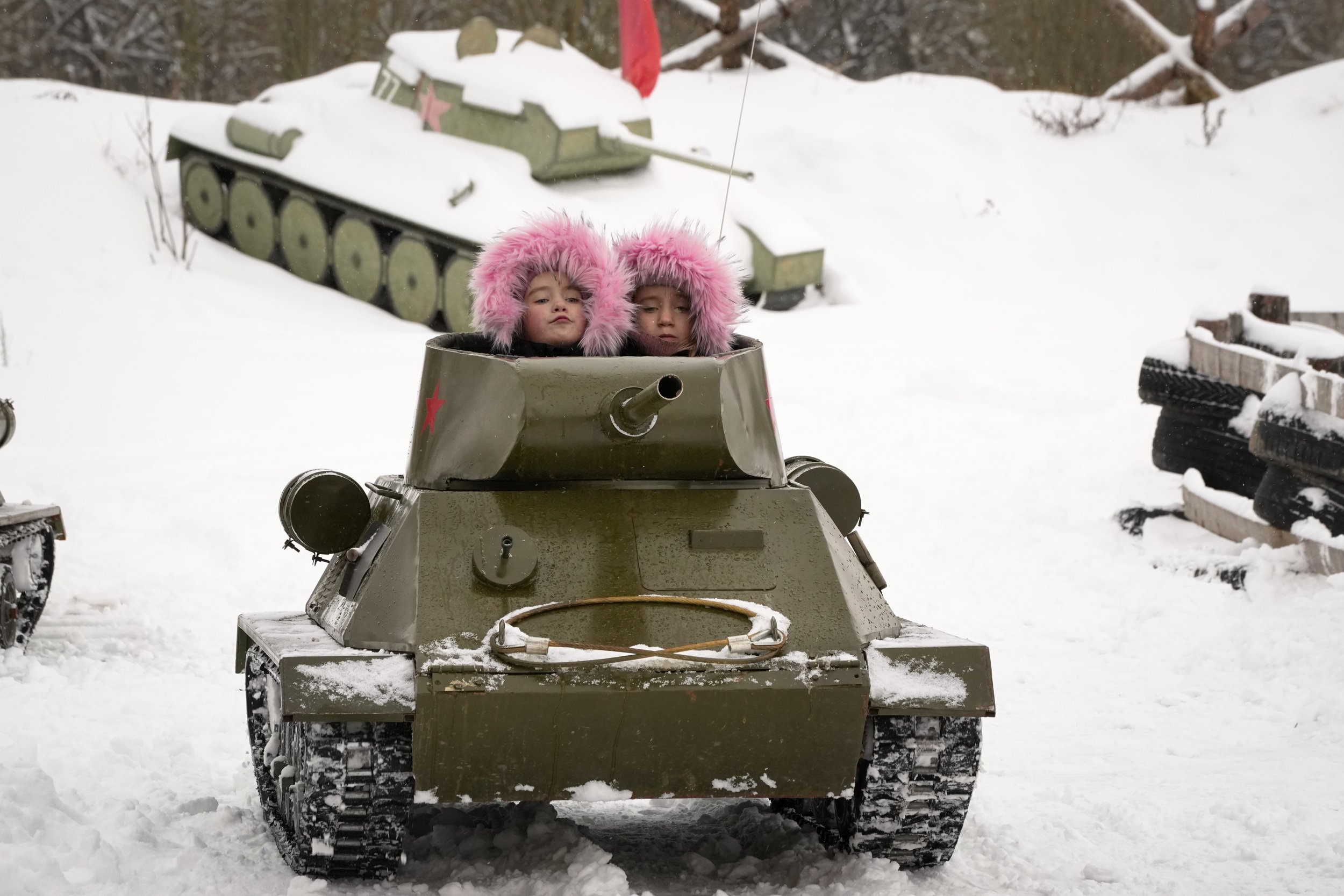 Children ride a model of World War II-era Soviet T-34 tank during a military historical festival at the family historical tank park outside St. Petersburg, Russia, on Feb. 4, 2023. (AP Photo/Dmitri Lovetsky)