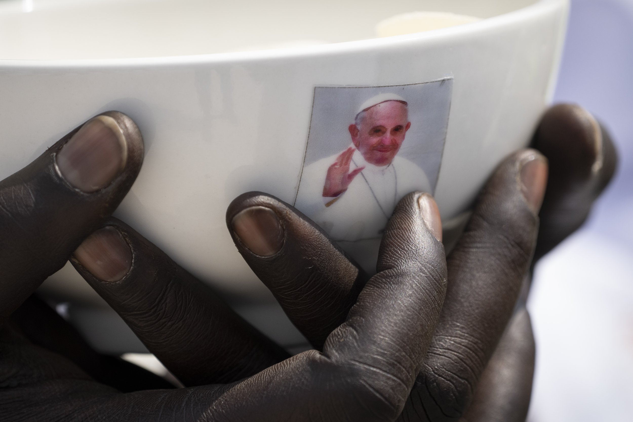  A priest holds a sacrament bowl with a photo of Pope Francis at a Holy Mass at the John Garang Mausoleum in Juba, South Sudan, Sunday, Feb. 5, 2023. Pope Francis was in South Sudan on the final day of a six-day trip that started in Congo, hoping to 