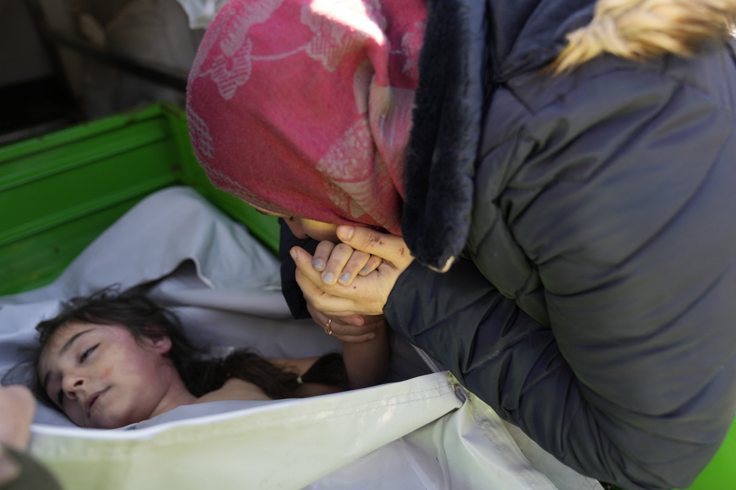  A Syrian mother kisses the hand of her daughter, who was killed in a powerful earthquake that struck southern Turkey and Syria three days earlier, at the Turkish crossing point of Cilvegozu, in Reyhanli, southeastern Turkey, on the border of Syria, 