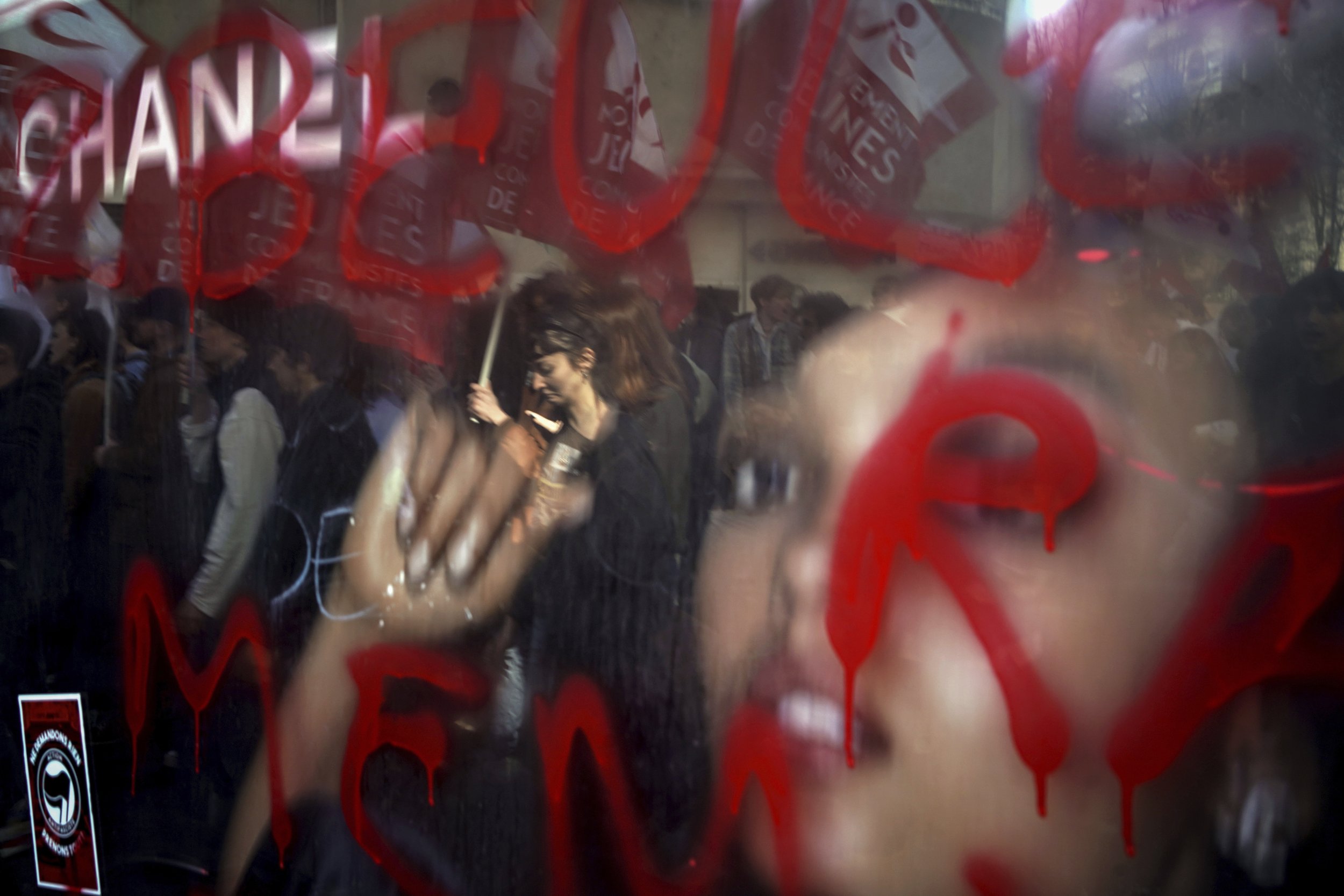  Opponents of French President Emmanuel Macron's pension plan are reflected in a billboard during a protest in Lyon, France, on March 15, 2023. (AP Photo/Laurent Cipriani) 