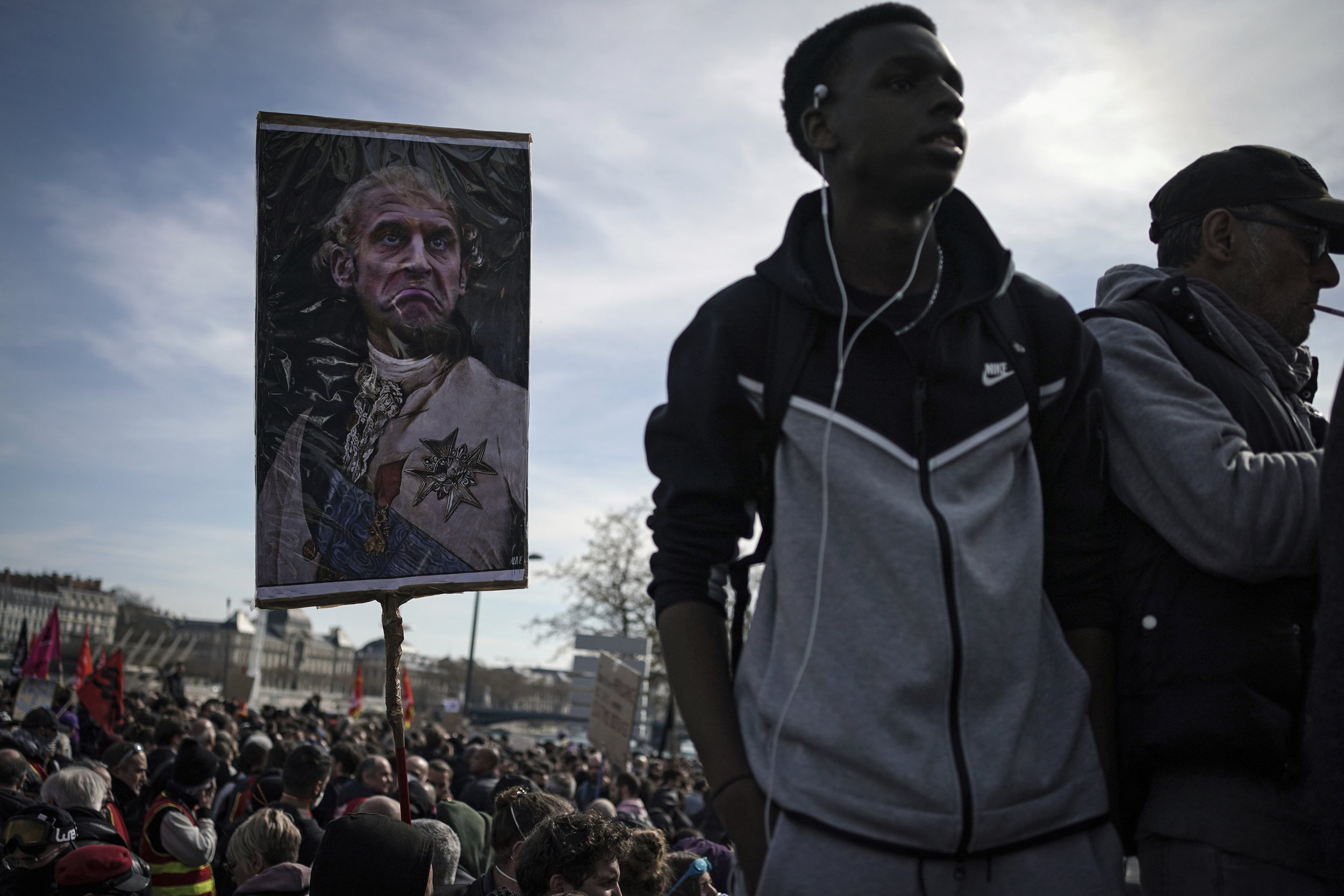  A protester holds a picture representing Emmanuel Macron dressed as a king during a demonstration against unpopular pension reforms and Macron's push to raise France's legal retirement age from 62 to 64, in Lyon, France, on March 28, 2023. (AP Photo
